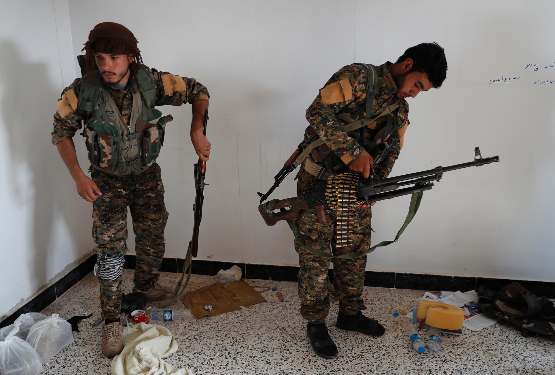En arabisk (till höger) och en kurdisk medlem i den USA-stödda SDF-milisen förbereder en insats mot terrorrörelsen Islamiska staten. Arkivbild.