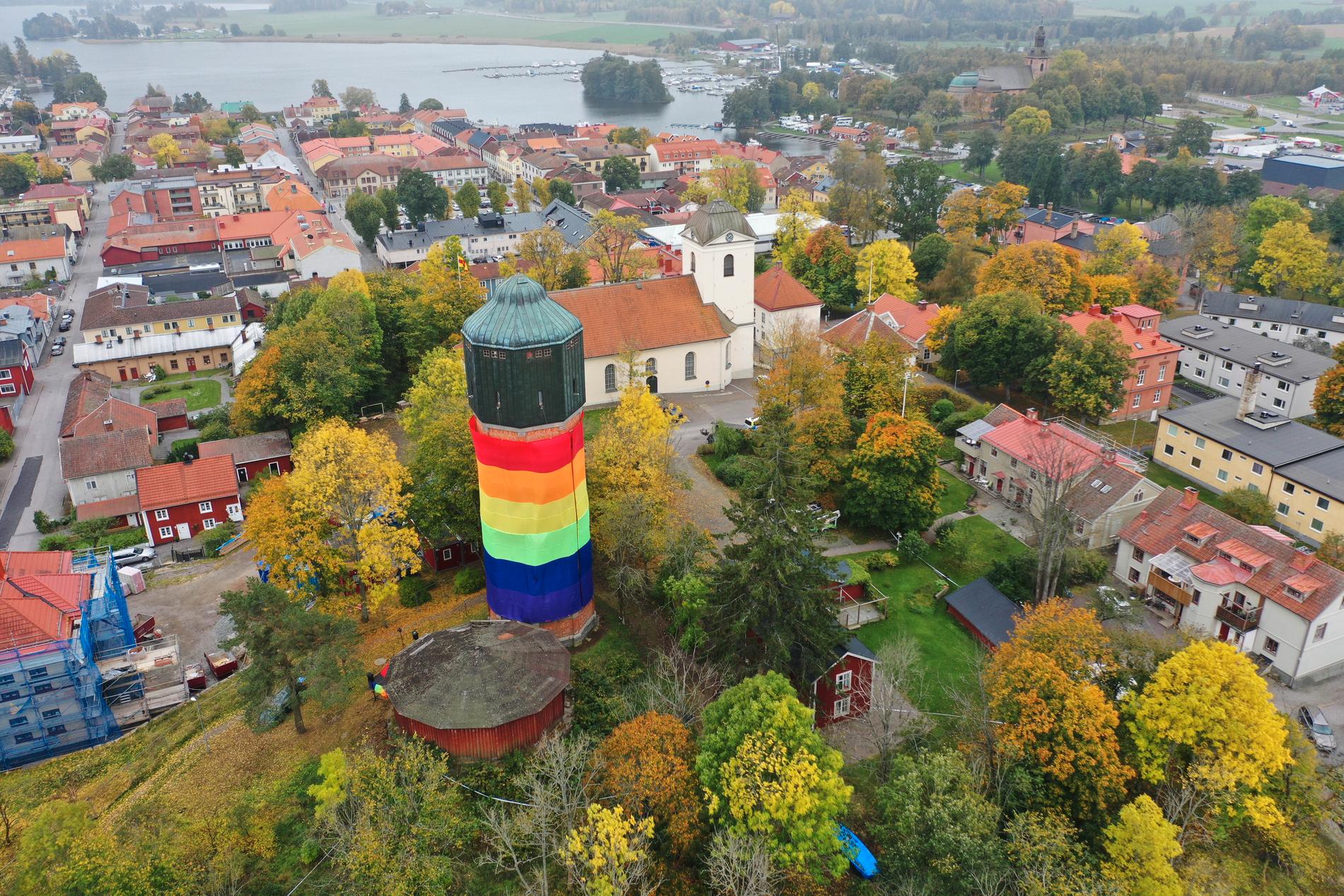 Flygbild över vattentornet i Akersund där byggnaden klätts i regbågsfärger under Askersunds lakeside pride.
