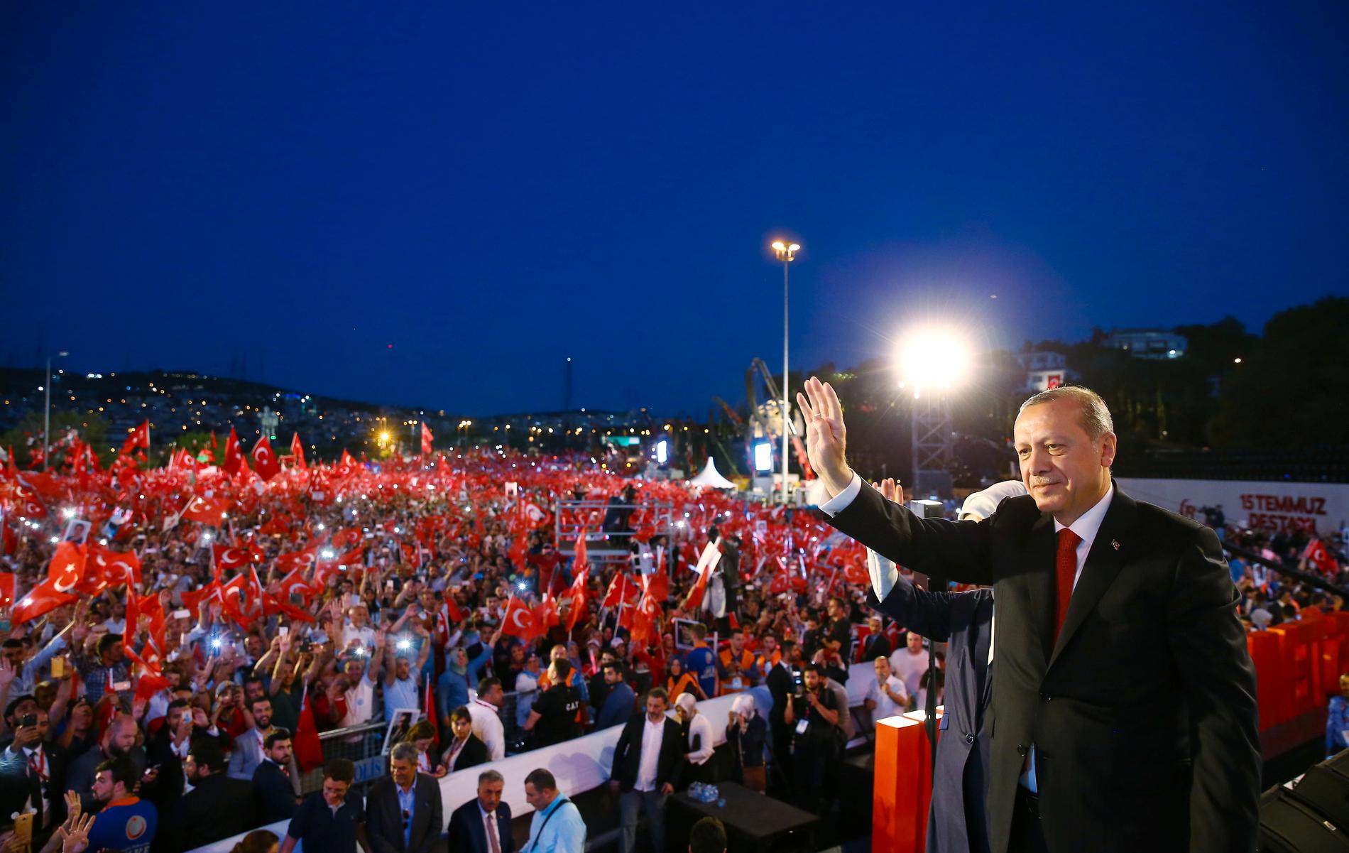 Den turkiska presidenten Recep Tayyip Erdogan vinkar till sina anhängare i Istanbul på årsdagen efter det misslyckade kuppförsöket.