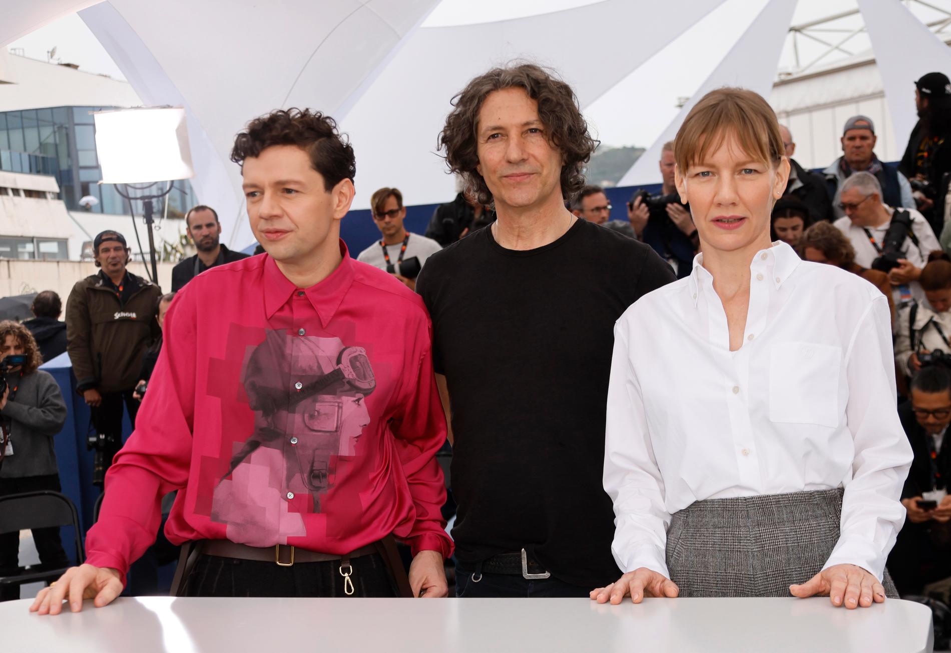Den brittiske regissören Jonathan Glazer omgiven av skådespelarna Christian Friedel och Sandra Hüller på filmfestivalen i Cannes där "The zone of interest" fick stora jurypriset i fjol. Arkivbild.