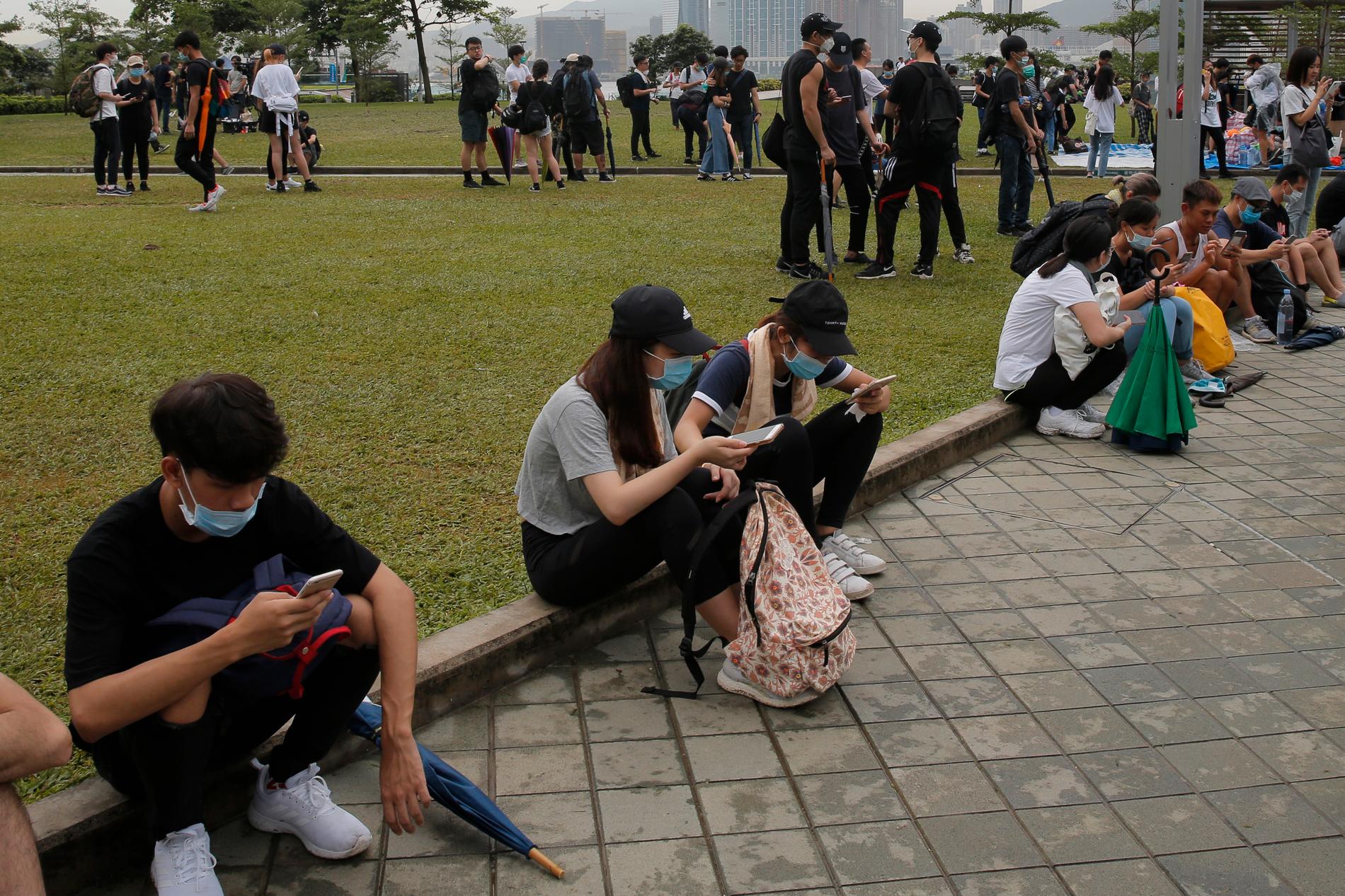 Demonstranter i Hongkong använder sina telefoner.