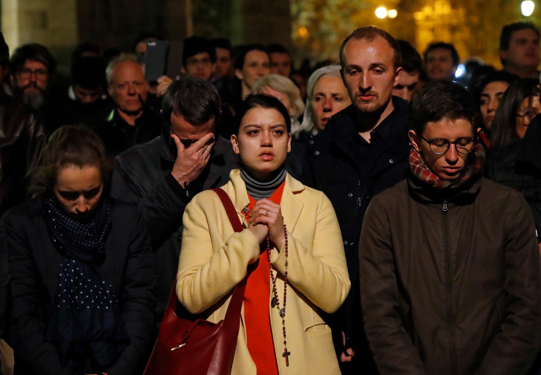 Chockade åskådare ser på när branden rasar i Notre-Dame-katedralen.