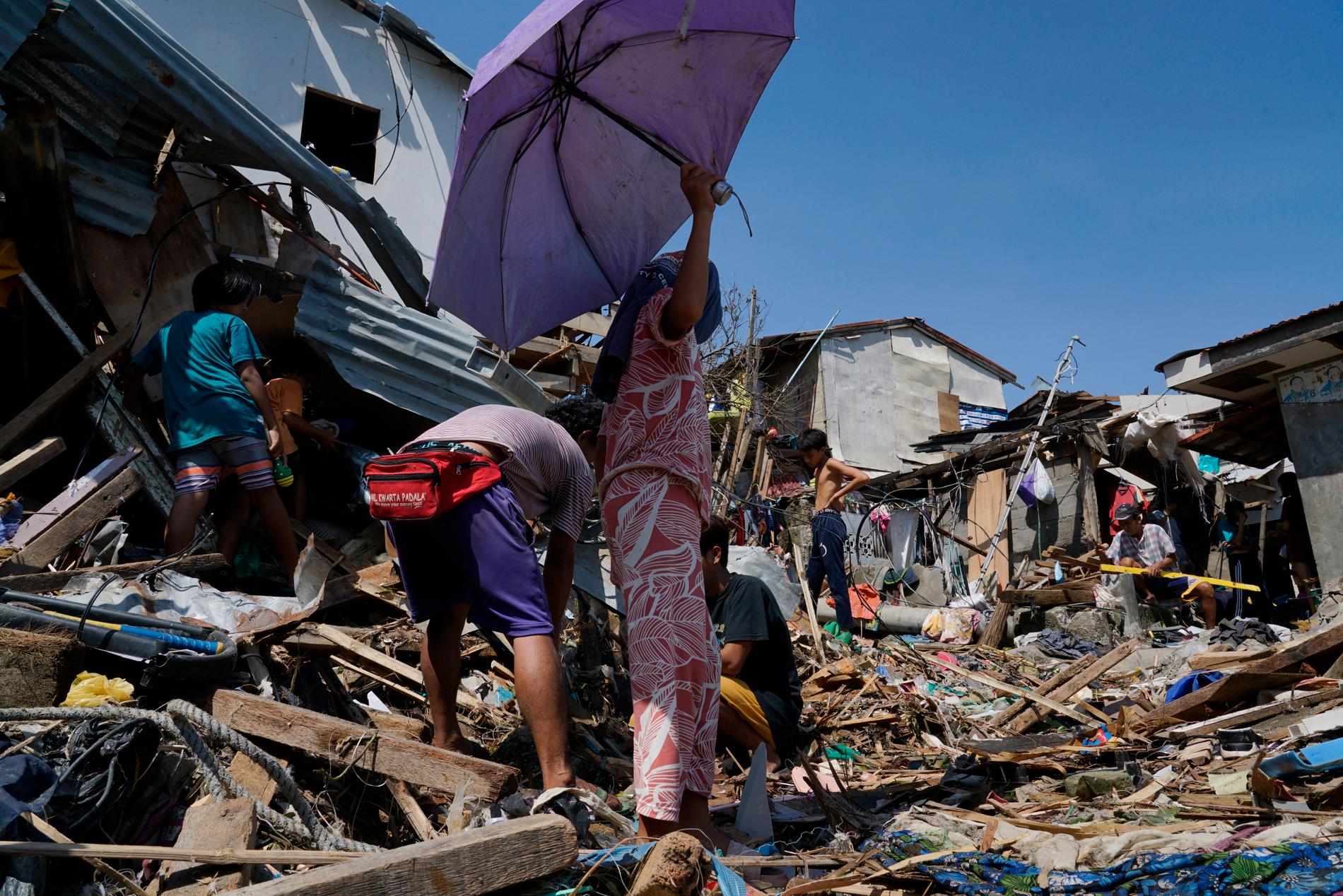 Invånare i Talisay i Cebu-provinsen i centrala Filippinerna försöker räddar vad som räddas kan ur bråten som var deras hem före tyfonen. 