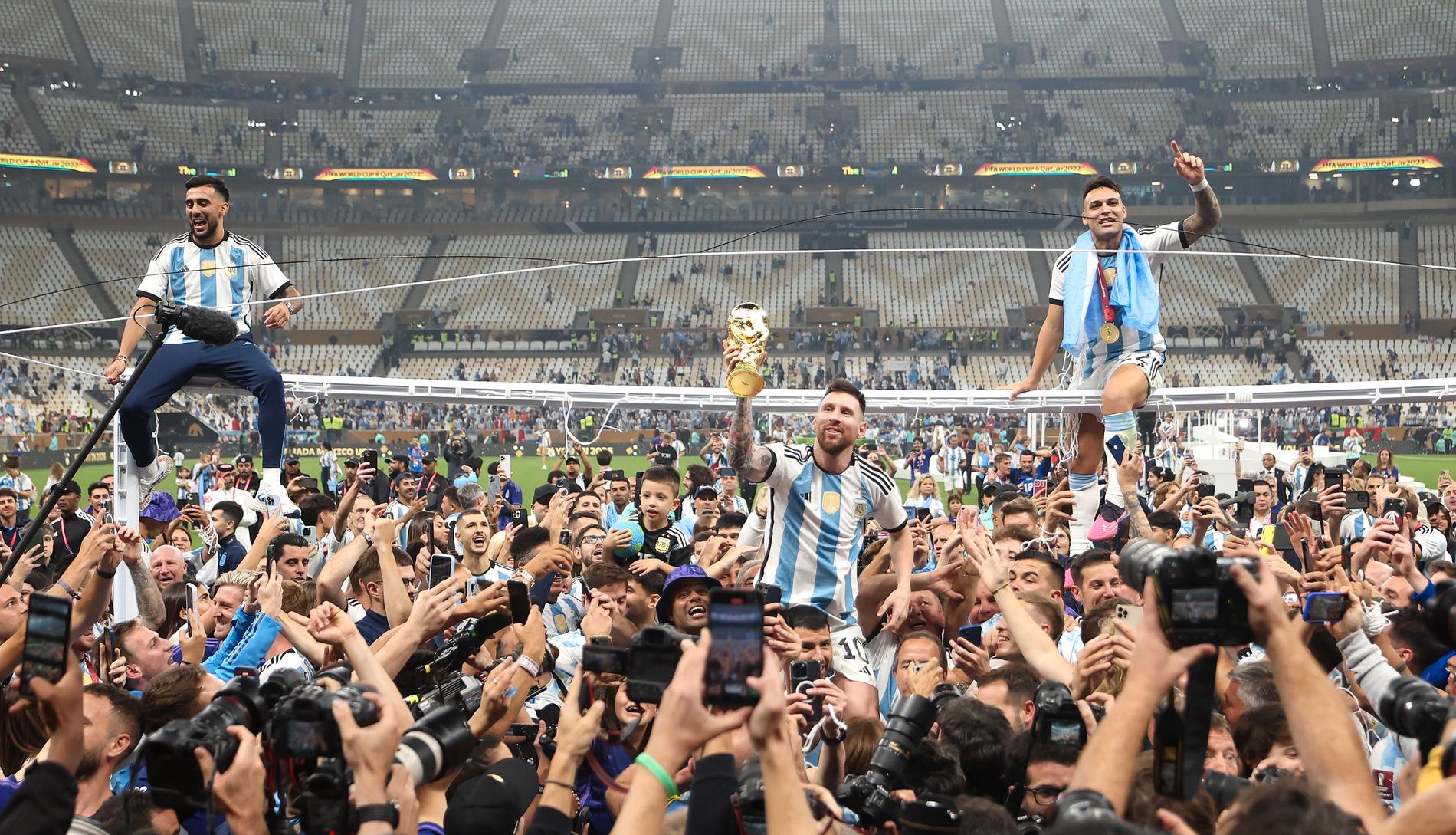 Leo Messi bär runt på Sergio Agüeros axlar – iklädd matchtröja med tre stjärnor. 