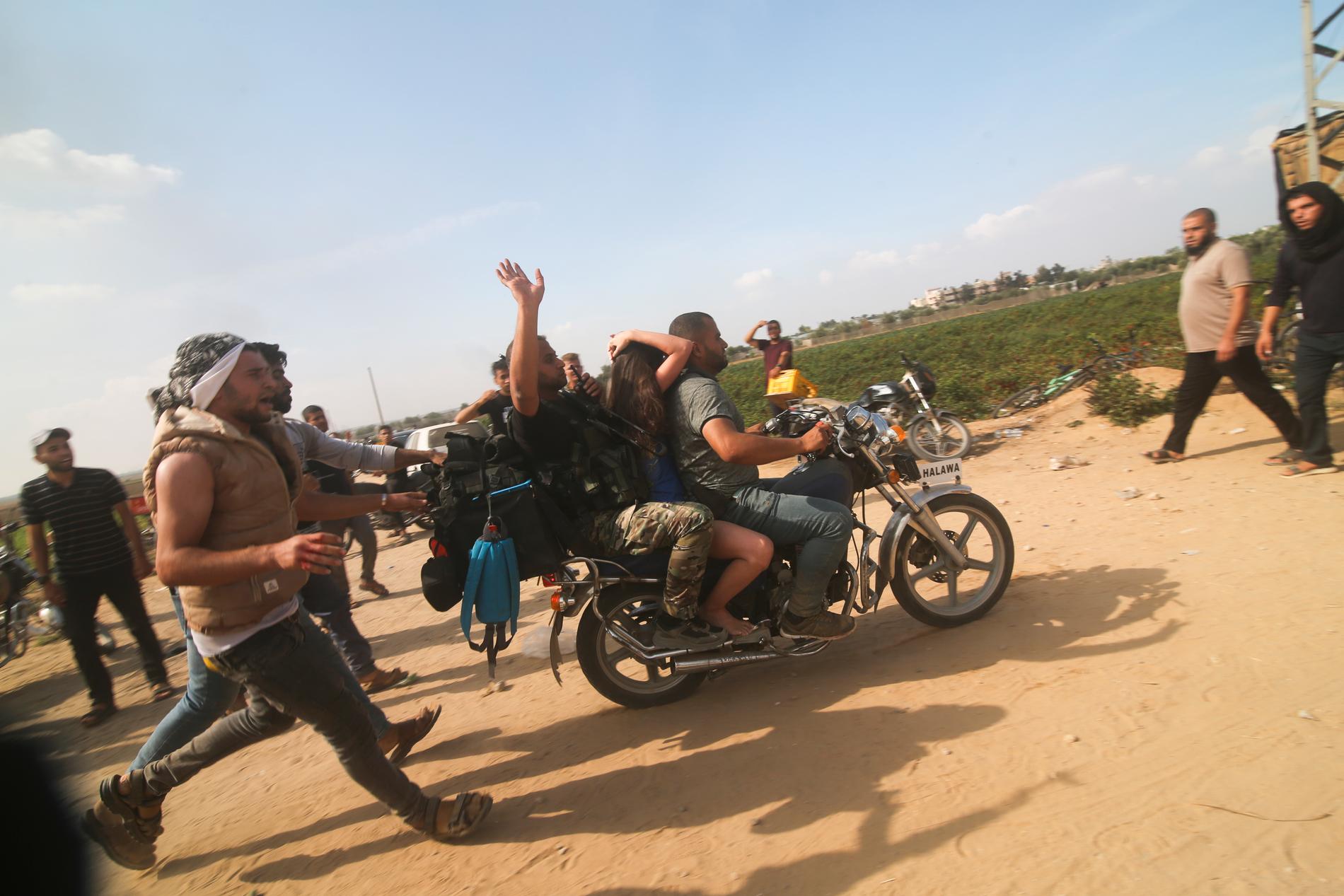 Hamasmän transporterar en israelisk gisslan från kibbutzen Kfar Azza till Gazaremsan, den 7 oktober, 2023.