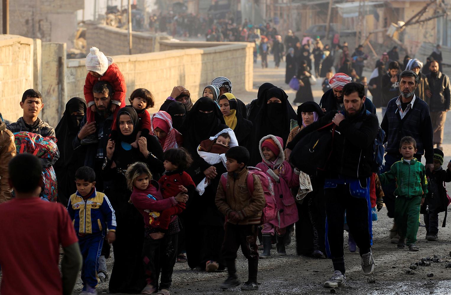 Människor flyr undan striderna i Mosul. Obs: Bilden tagen vid ett annat tillfälle än det som återges i artikeln.