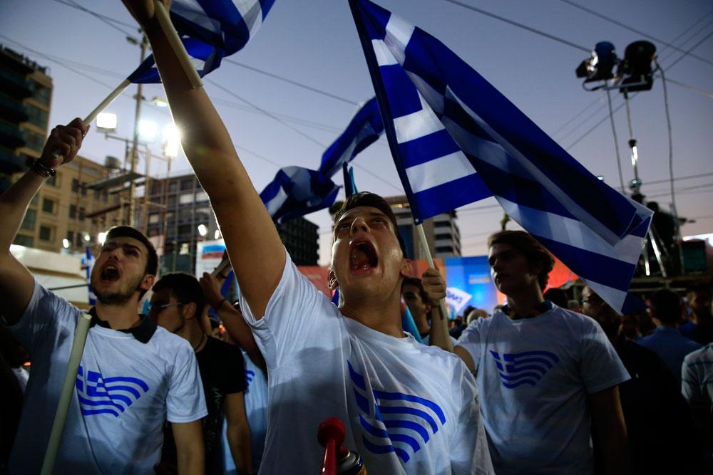 Anhängare till konservativa partiet Ny Demokrati skriker slagord innan partiledaren Evangelos Meimarakis ”uppvärmningstal” på Omoniatåget i Aten 17 september 2015.