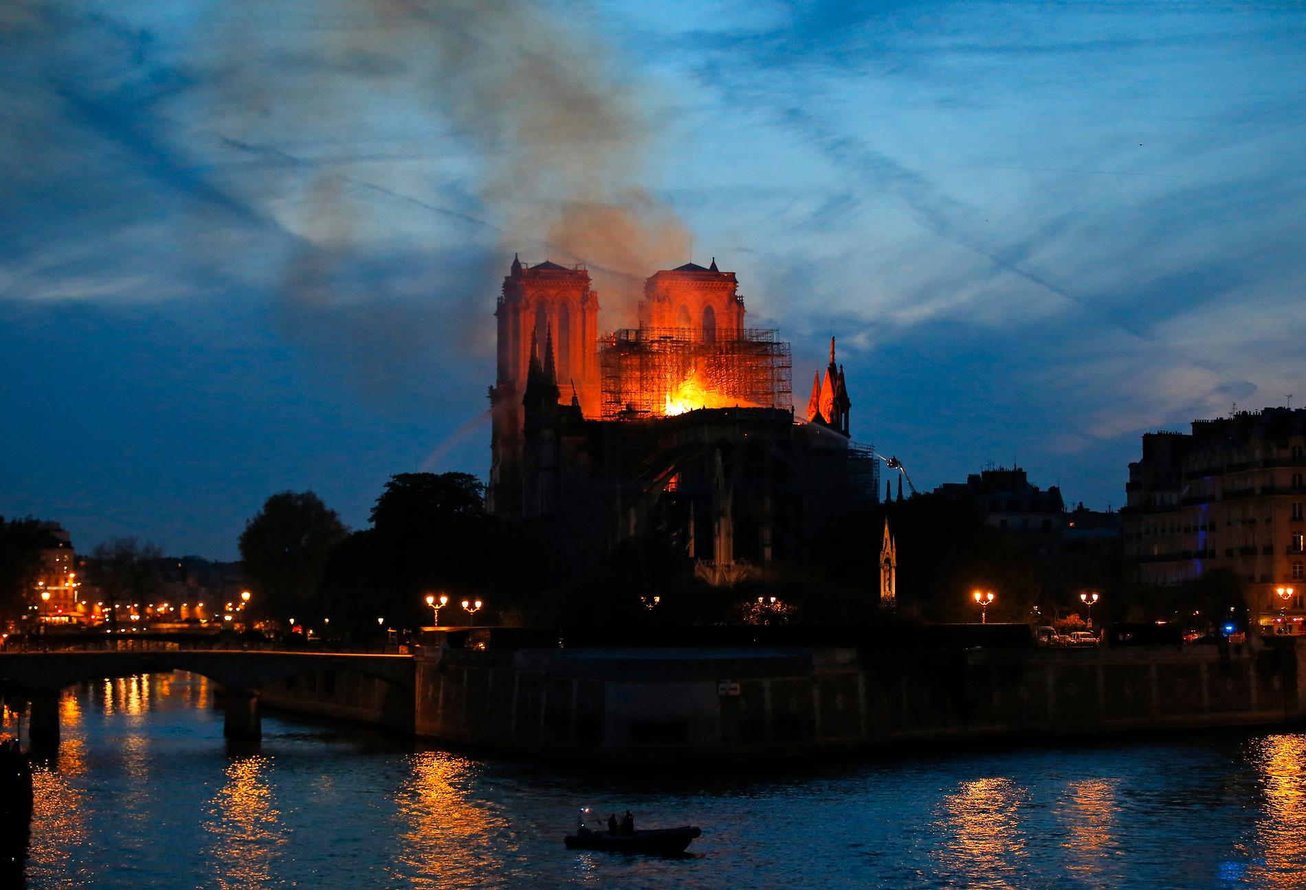 Brandmän försöker att släcka branden i Notre-Dame.