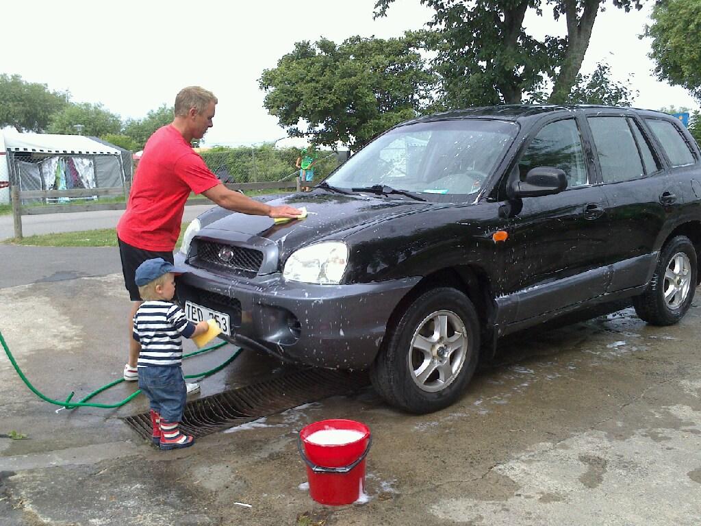 Far och son tvättar bilen, Köpingsvik, Öland.