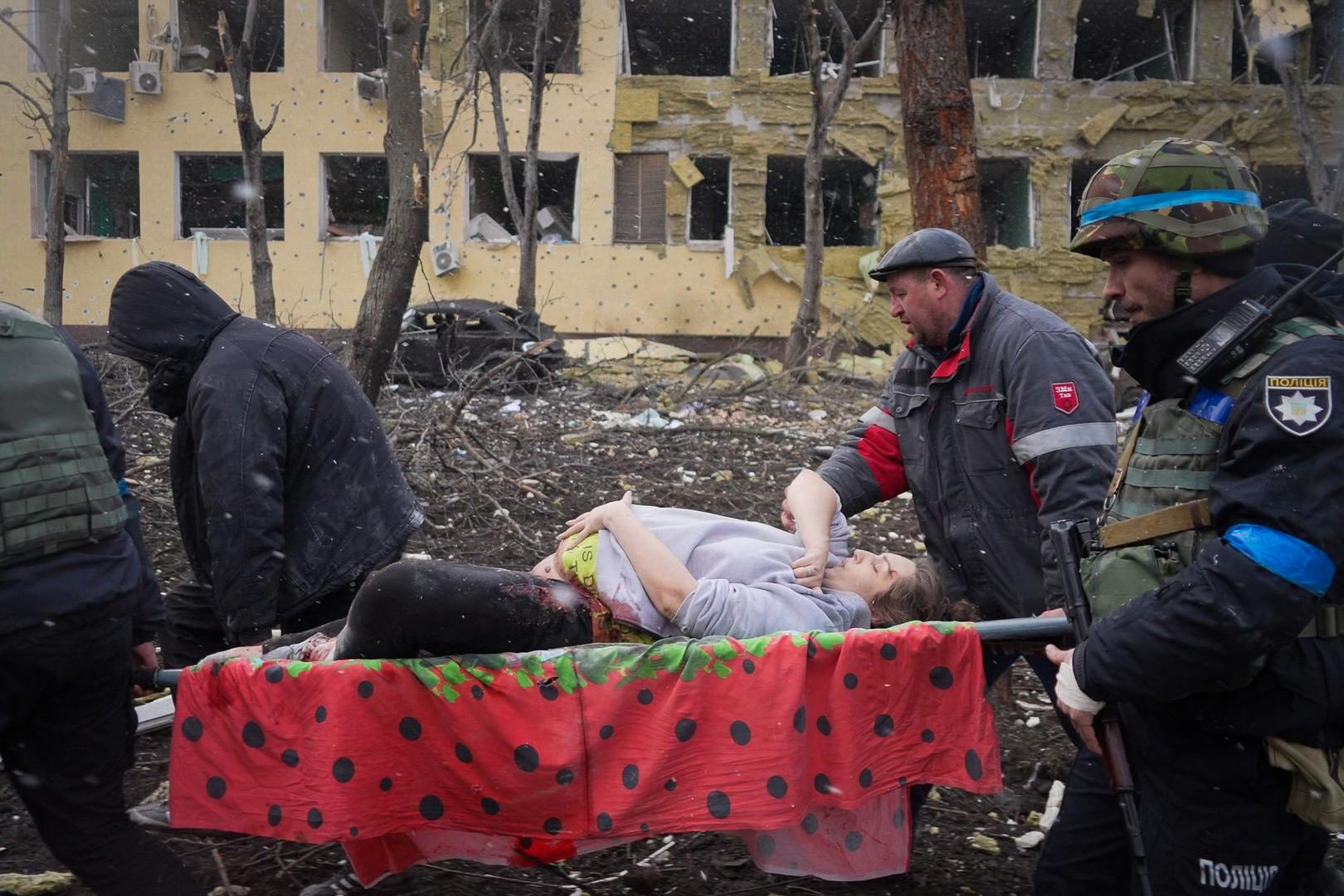 En gravid kvinna vars bäcken krossats i en rysk flygattack bärs ut från förlossningssjukhuset i Mariupol. Hon flyttades till ett annat sjukhus, men avled senare av sina skador. Bild från filmen ”20 Days in Mariupol”.     