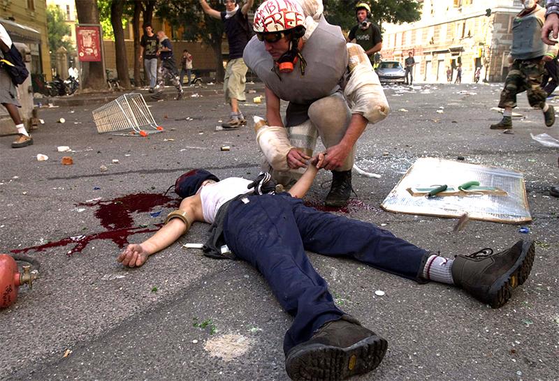 G8-mötet i Genua 2001 Anarkisten Carlo Giuliani ligger döende på gatan skjuten i huvudet av polisen med två skott efter att ha försökt kasta in en brandsläckare i ett polisfordon. Foto: AP
