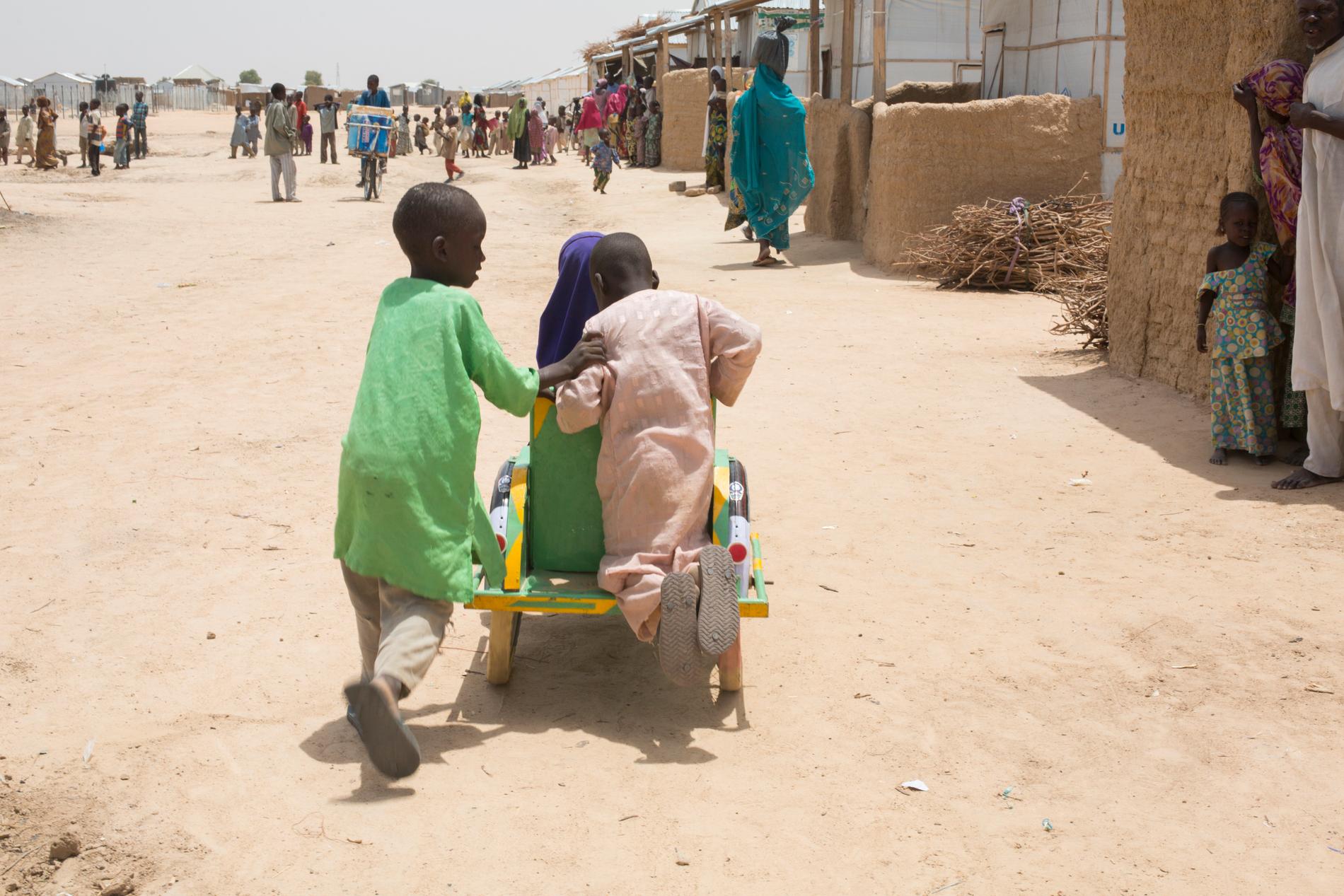 Barn leker utanför Bakassilägret i Maiduguri i delstaten Borno. Fler än två miljoner människor flydde Boko Harams skräckvälde. Nu vill nigerianska staten att de börjar återvända.
