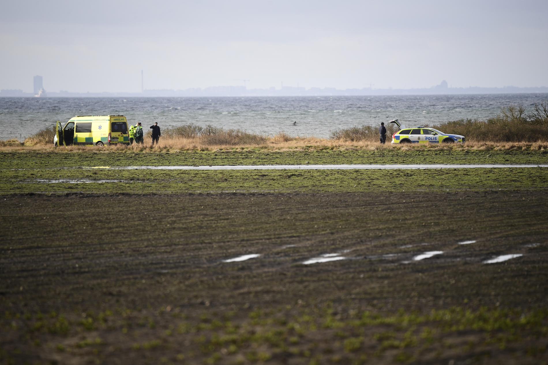 Polis och ambulans på fyndplatsen vid Lundåkrabukten söder om Landskrona där en död person hittades.