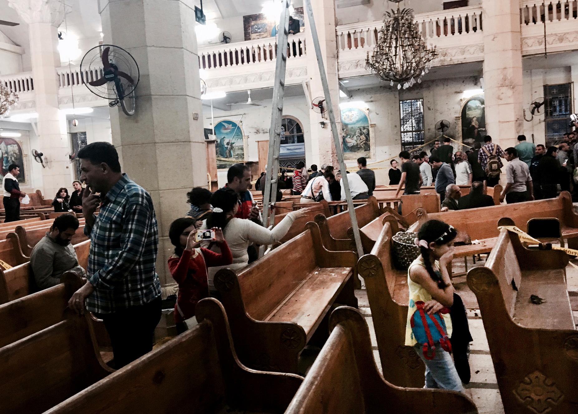 Människor tittar på förödelsen i en kyrka i Tanta i Egypten efter ett bombdåd i april i fjol.