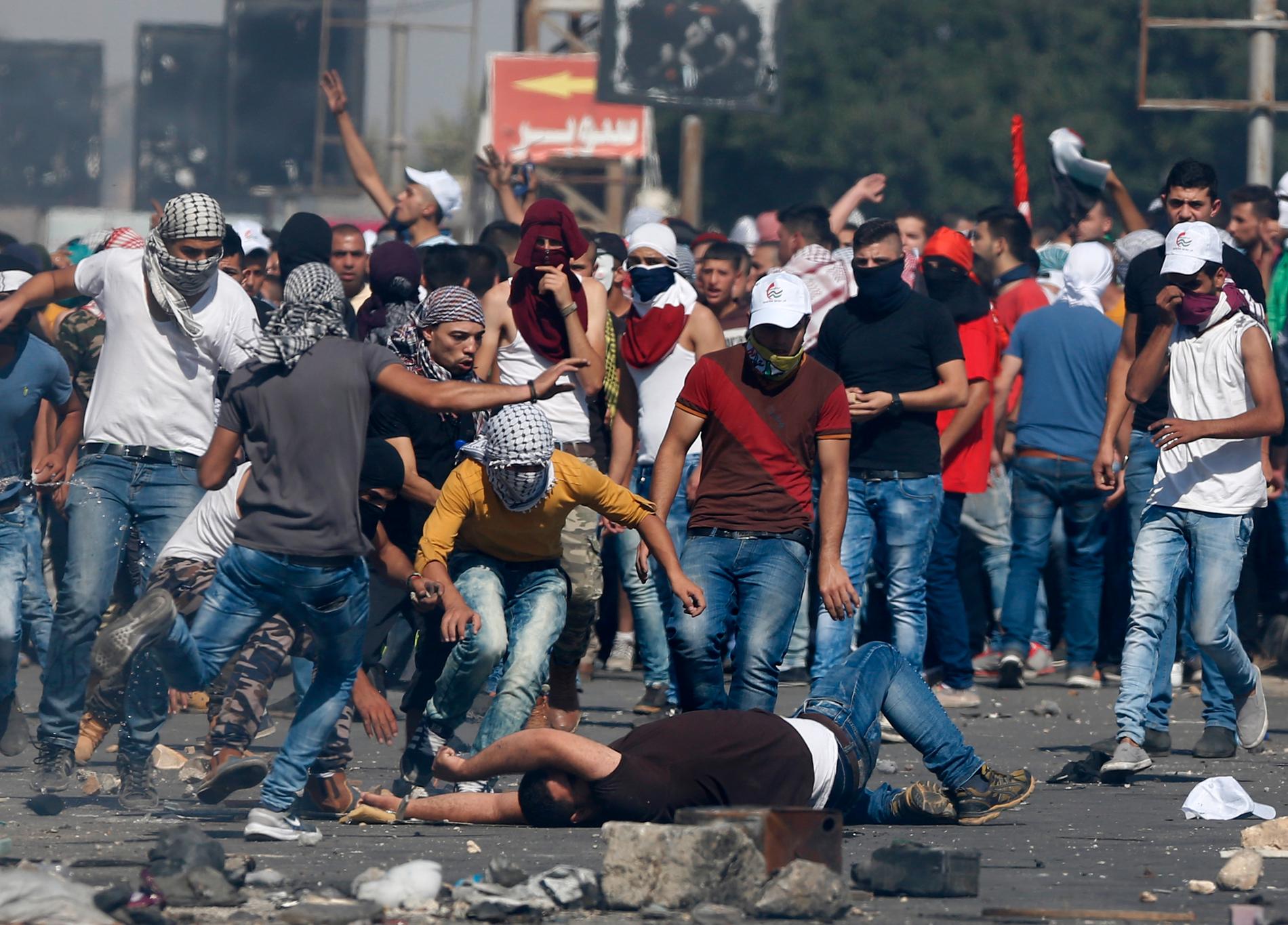 En skadad palestinier får hjälp under de våldsamma protesterna.
