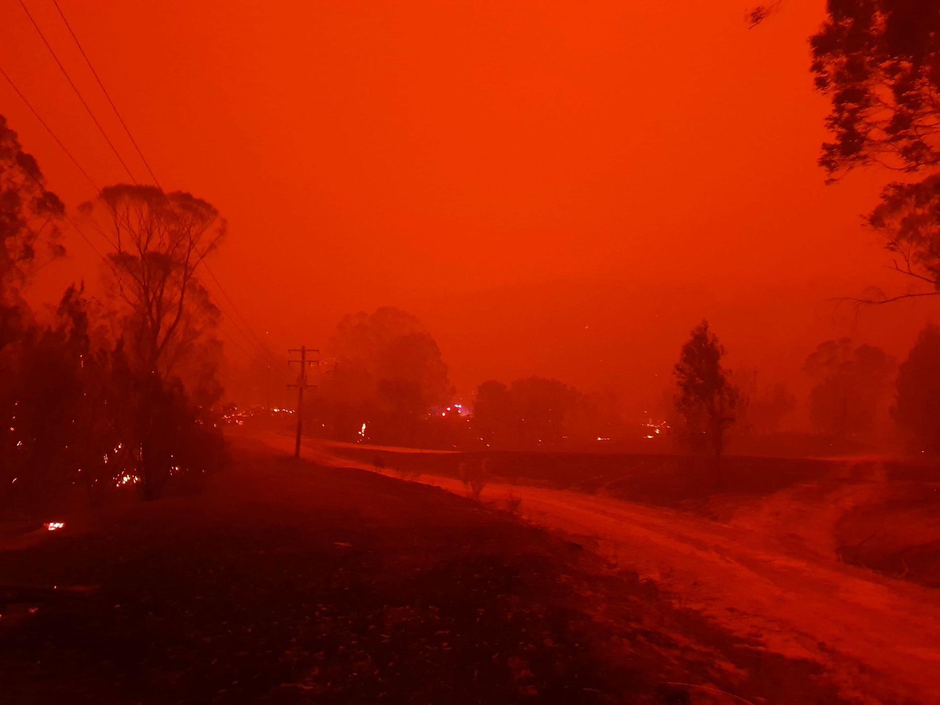 Byn Nerrigundah i södra New South Wales insvept i eld och rök. Bilden är tagen på nyårsafton förra året.