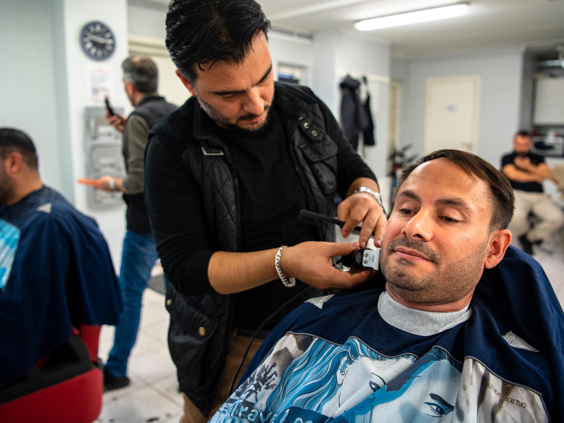 Mikail Yüksel rakar sig på en lokal salong i Fittja. ”Det är samma frisör som jag hade när jag bodde i Kulu”, säger han. 