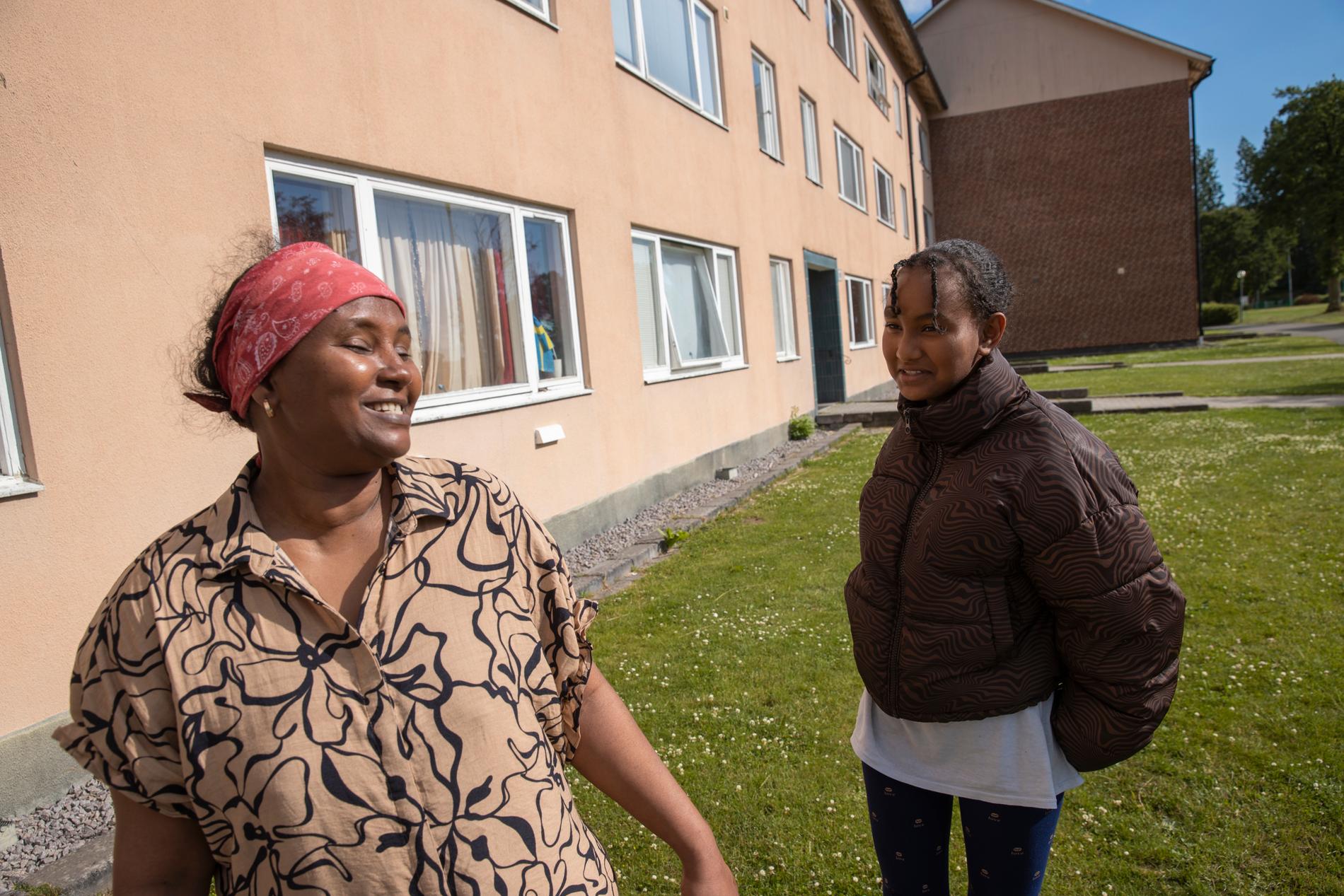 Tsega Heli och hennes dotter utanför deras lägenhet som ska rivas inom några år.  
