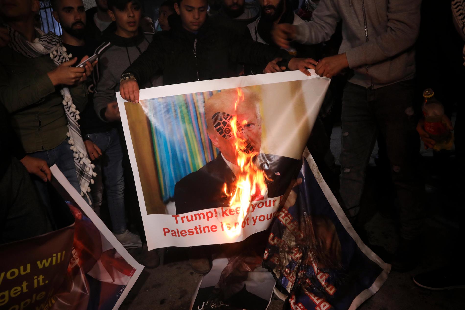 Palestinier bränner en affisch med Trumps bild under en protest nära Betlehem på tisdagskvällen. ……