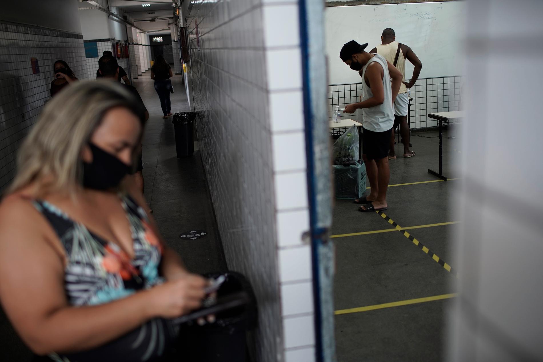Väljare, här i Rio de Janeiro, uppmanas att ta med egna pennor till vallokalerna, att hålla avstånd, och att desinficera händerna flera gånger.