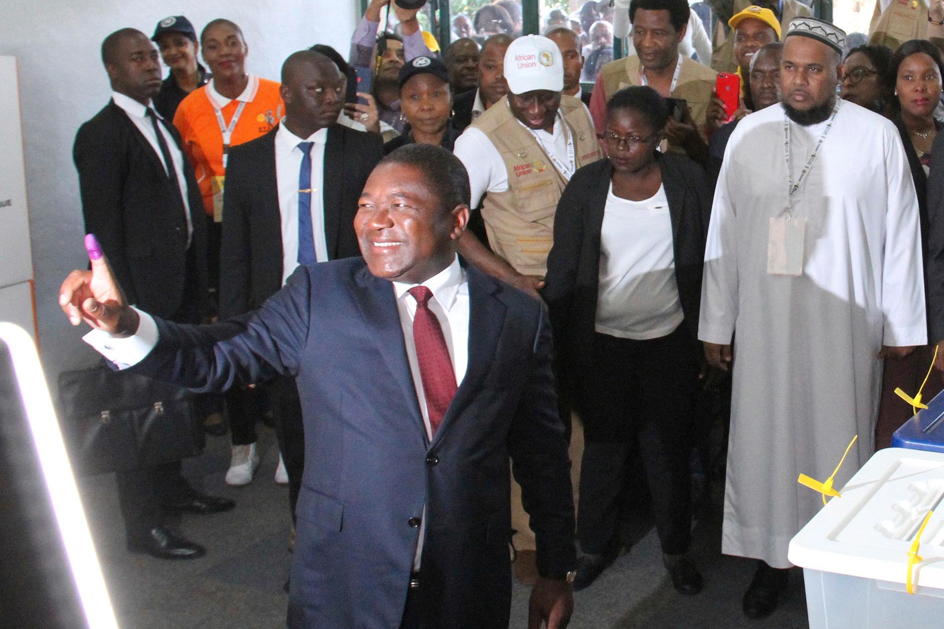 Moçambiques president Filipe Nyusi visar upp ett bläckfärgat finger för att visa att han röstat. Nyusi väntas bli omvald, men oppositionen väntas röna provinsiella framgångar.