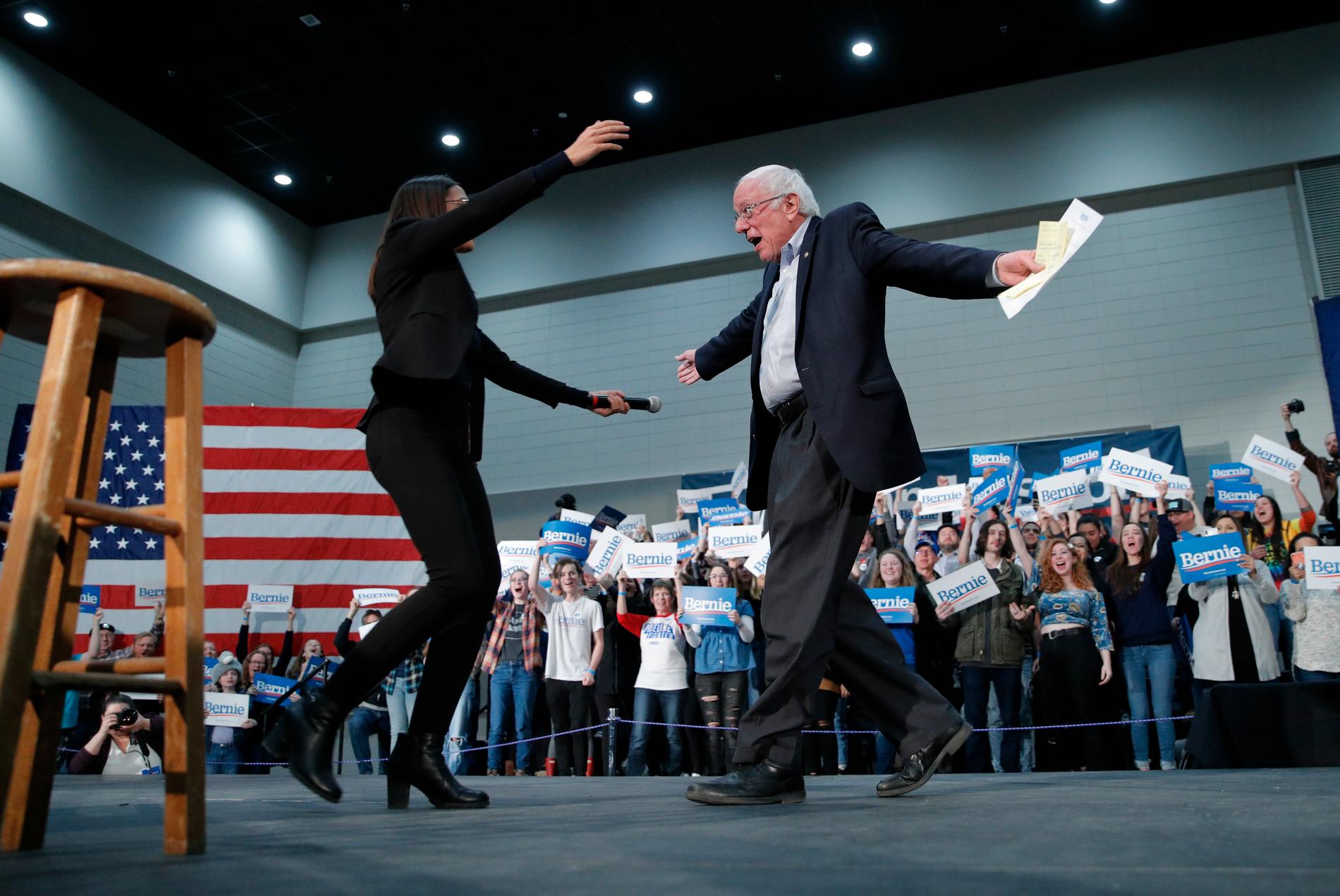 Presidentaspiranten och Vermontsenatorn Bernie Sanders välkomnas upp på scenen av den unga kongressledamoten Alexandria Ocasio-Cortez, som kampanjar för honom. Bilden är tagen i Sioux City i Iowa.