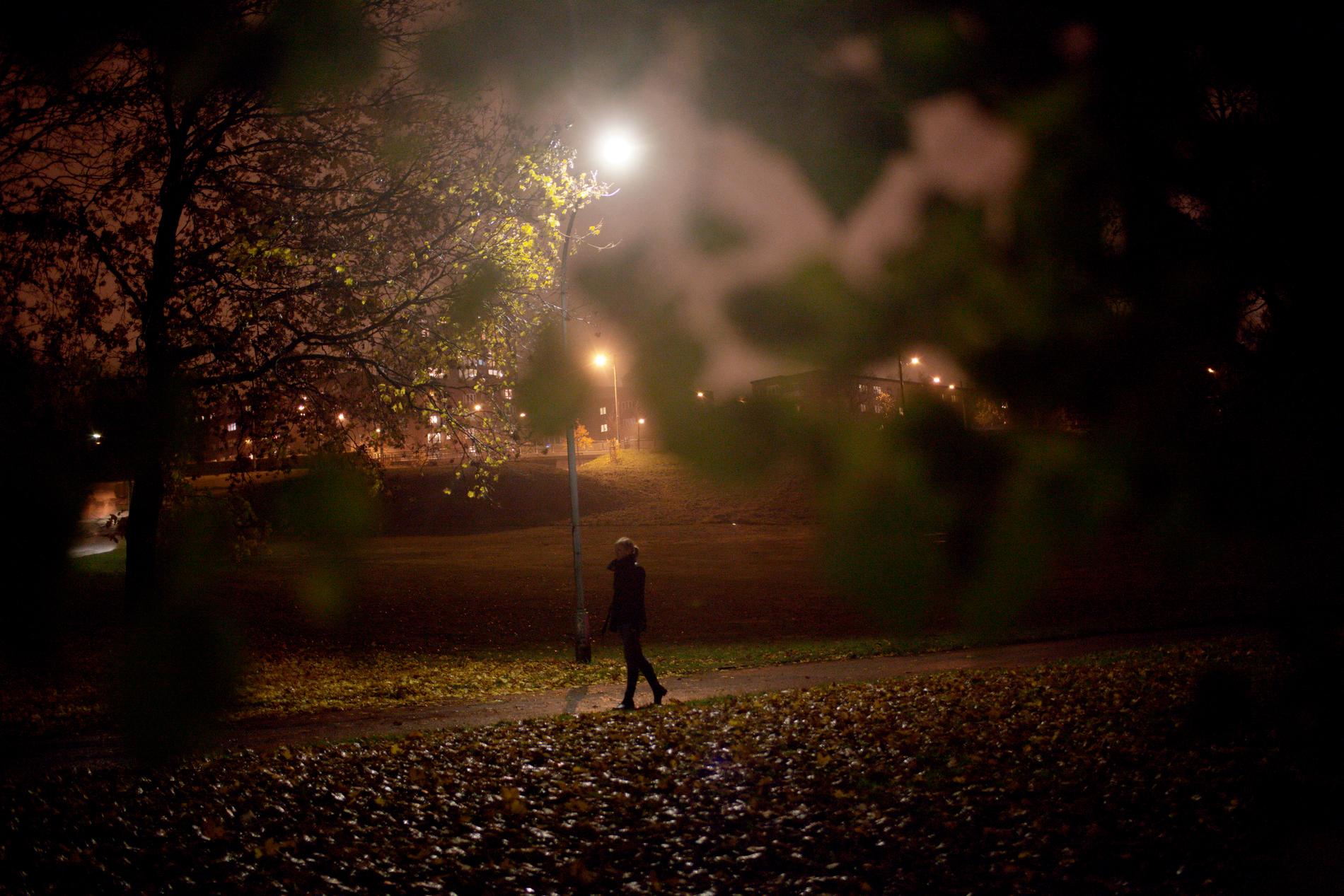 Kvinna i park på kvällen. Arkivbild. 