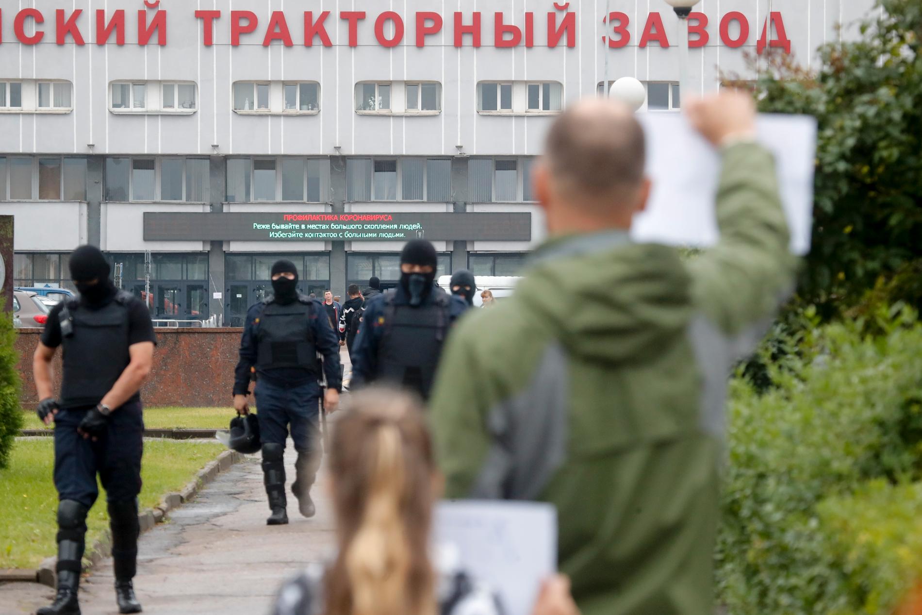 Demonstranter utanför traktorfabriken MTZ i Minsk drog sig undan när Omon-soldater hotfullt närmade sig.