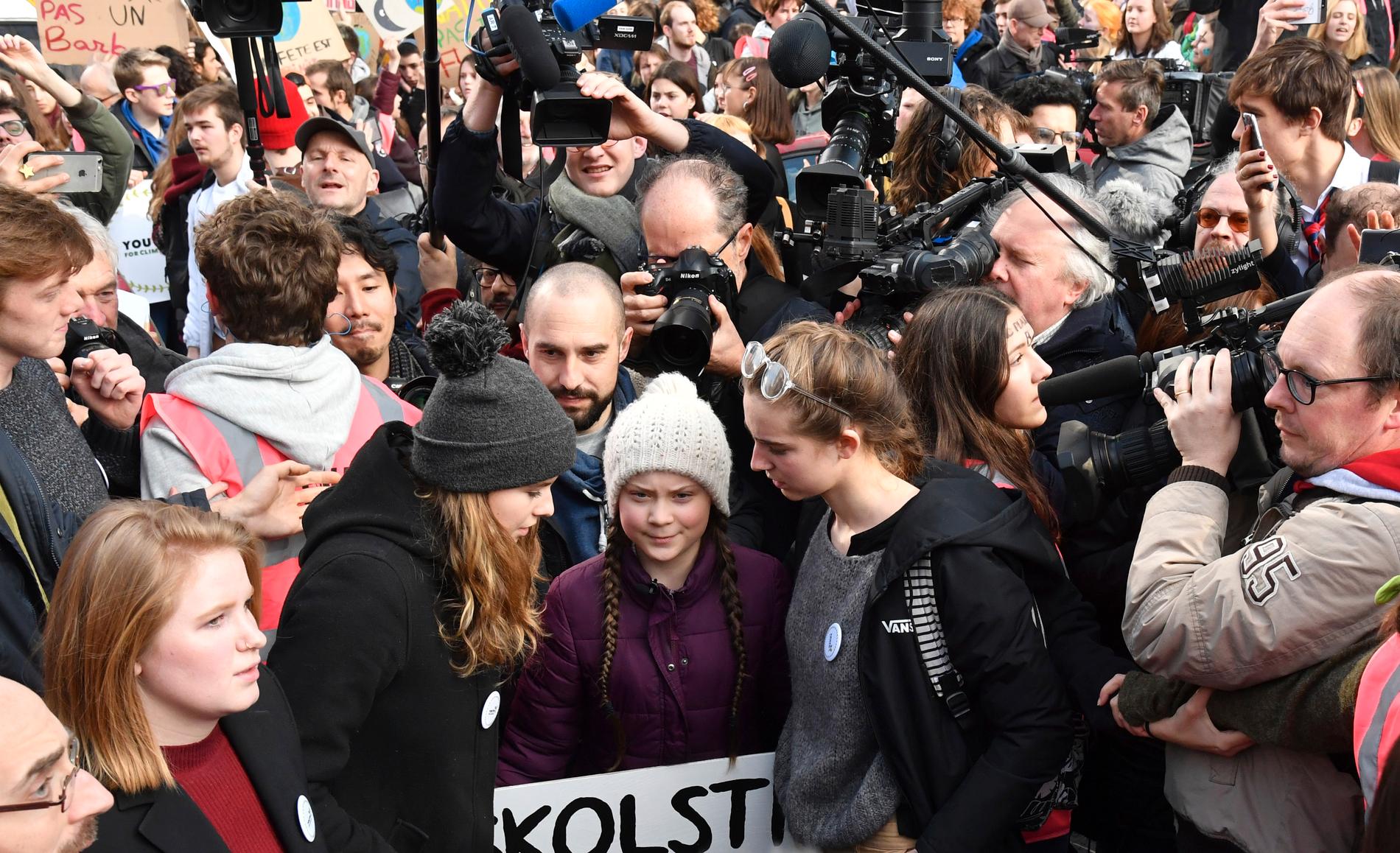 Svenska Greta Thunberg (mitten) omgiven av anhängare och journalister under en klimatdemonstration i Bryssel.