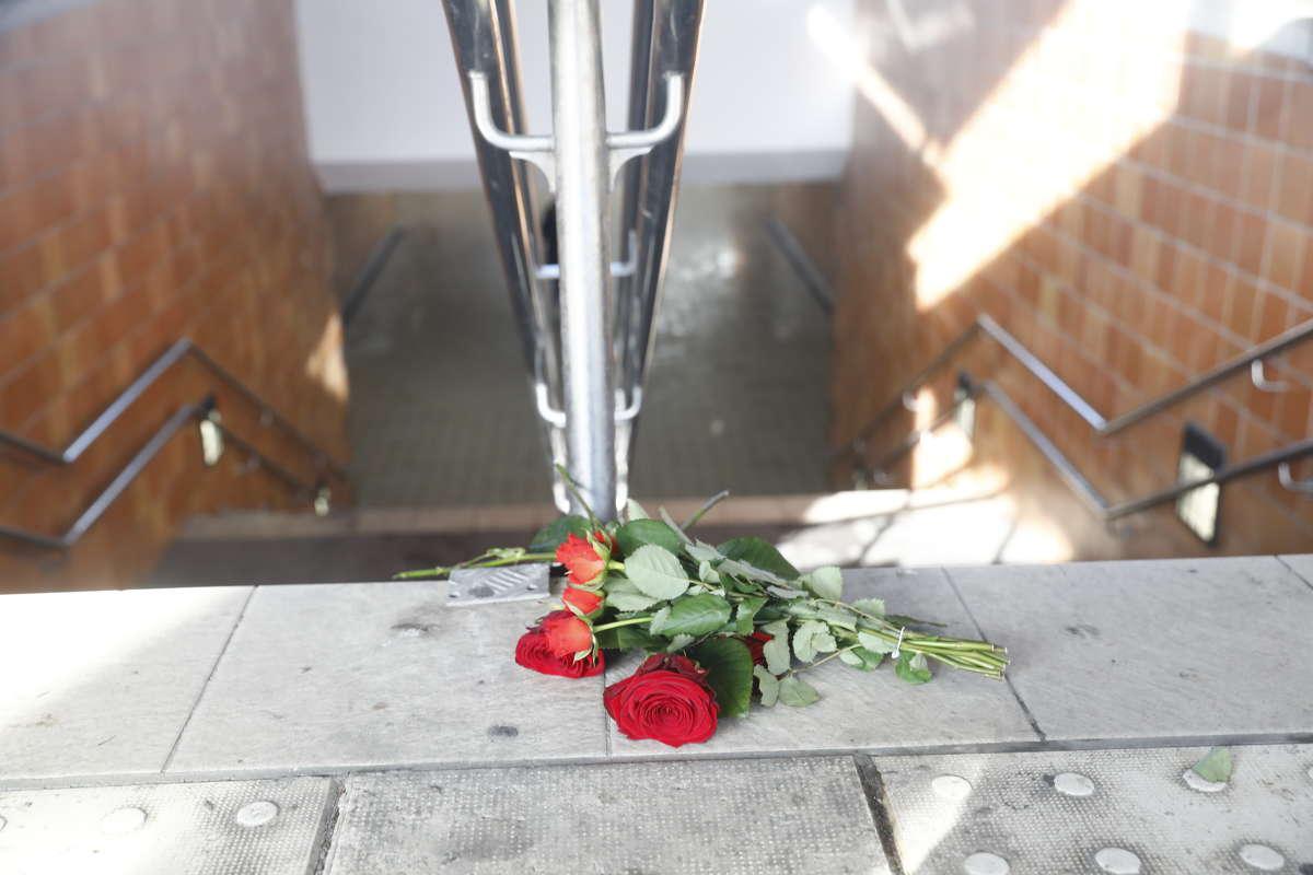 En bukett rosor ligger vid trappen till gångtunneln mellan perrongerna. 
