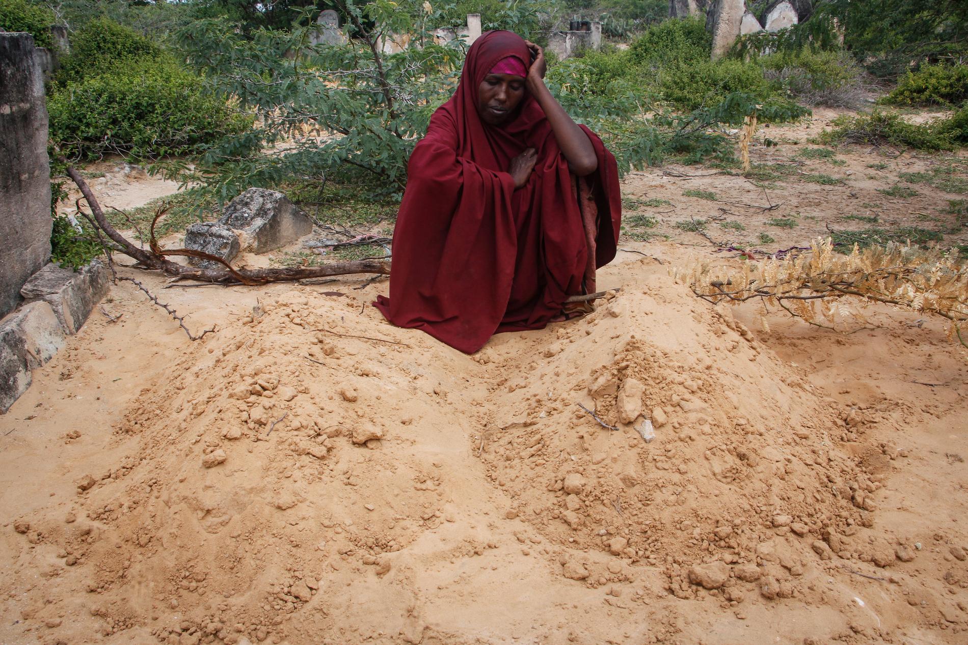 Fatuma Abdi Aliyow vid sina två söners gravar utanför Mogadishu. De avled nyligen av undernäringsrelaterade sjukdomar.