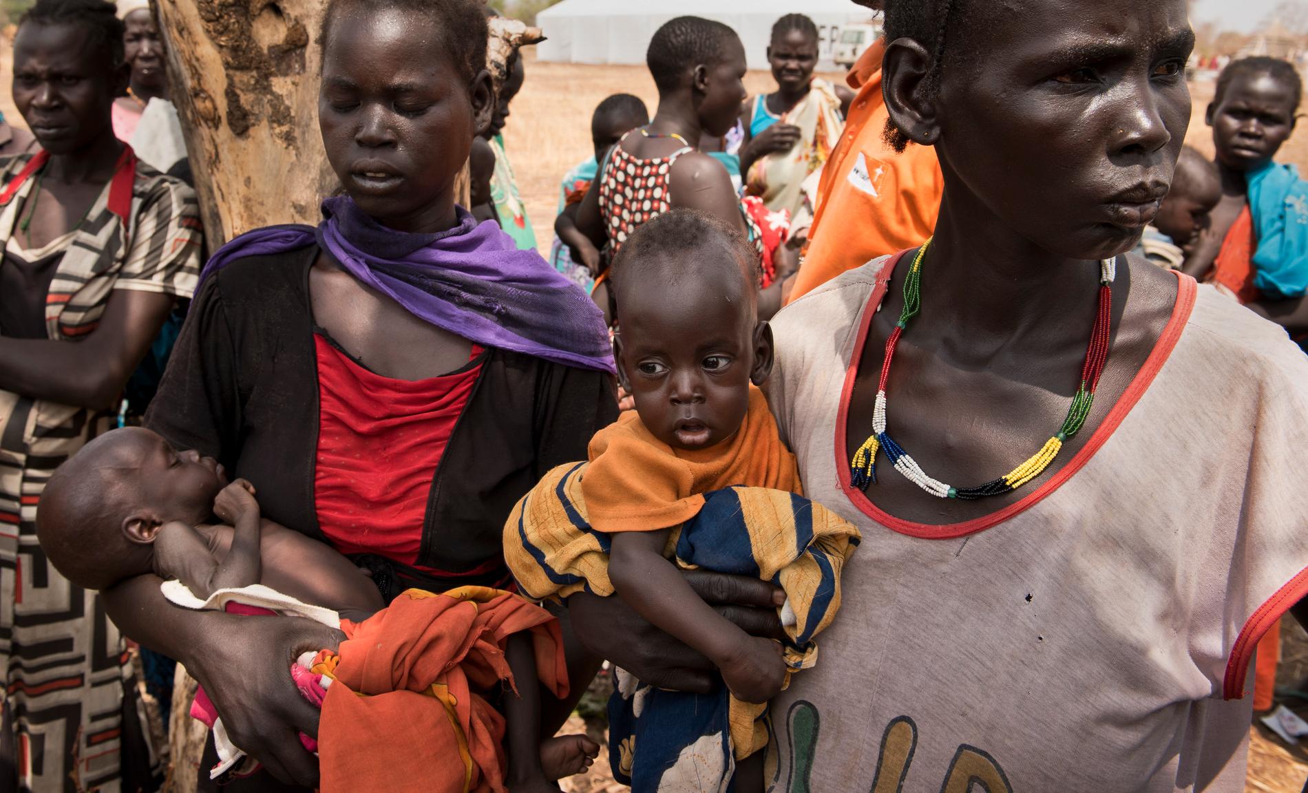 Abuk Garang (till höger) håller sin son William Deng och Adel Bol med sin dotter Akir Mayen på väg till matutdelning i Malualkuel i Sydsudan under fjolårets hungersnöd. Arkivbild.