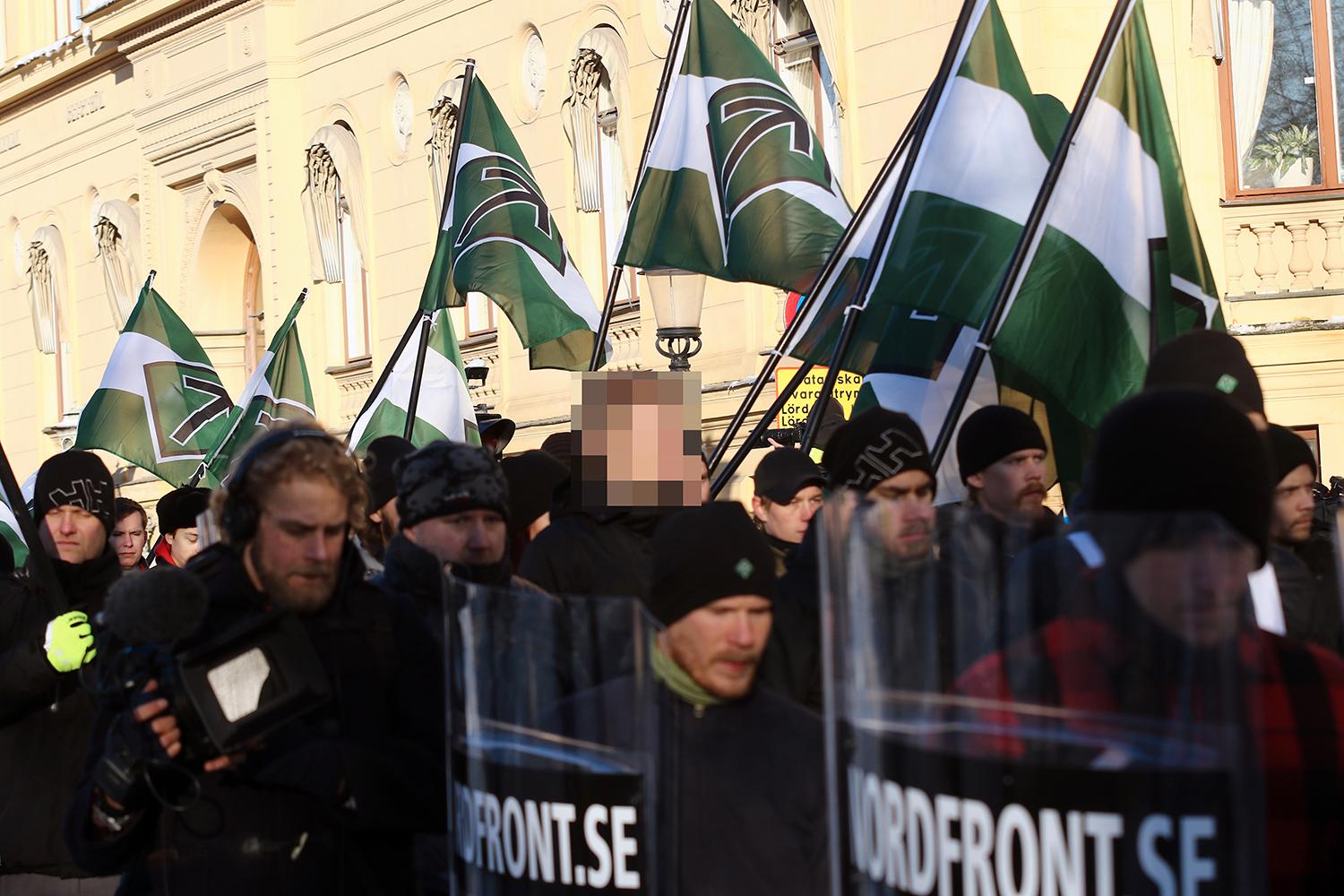 Den 20-årige misstänkte bombmannen är pixlad i mitten av bilden. Aftonbladet har valt att inte visa ansiktet på de misstänkta bombmännen före fällande dom. 