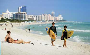På USA:s soldränkta kust, Miami Beach, samsas soldyrkarna och surfarna.