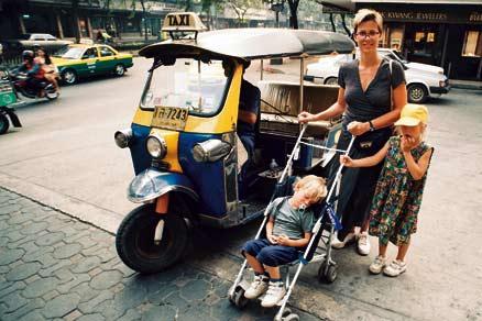 Bangkok 1996 Med en bra paraplyvagn kan man sova överallt! Arvid, 3, sover gott medan mamma Ann och systern Fredrika, 5, hjälps åt att dra vagnen.
