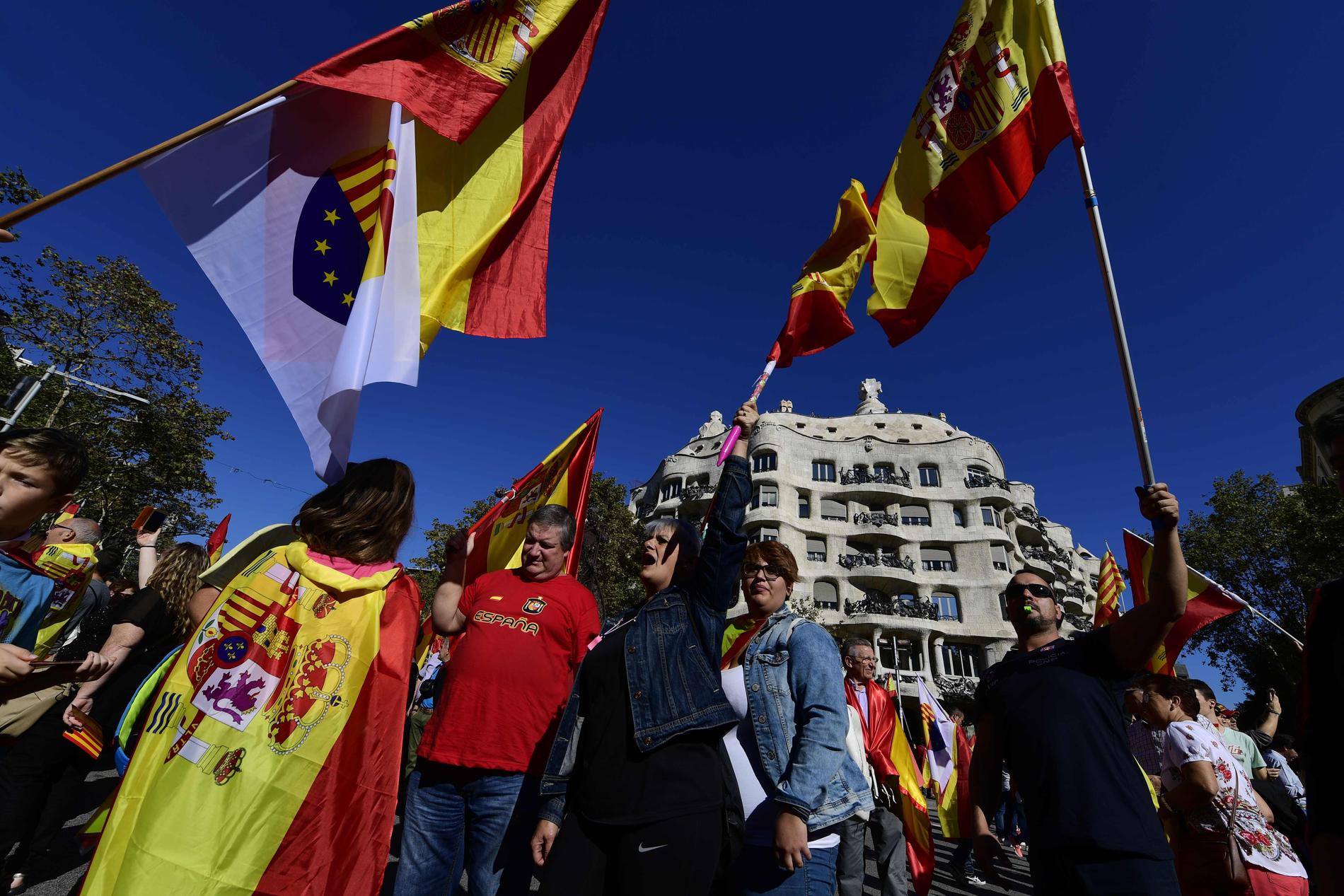 Människor viftar med spanska flaggor vid en manifestation i Barcelona för spansk enighet.