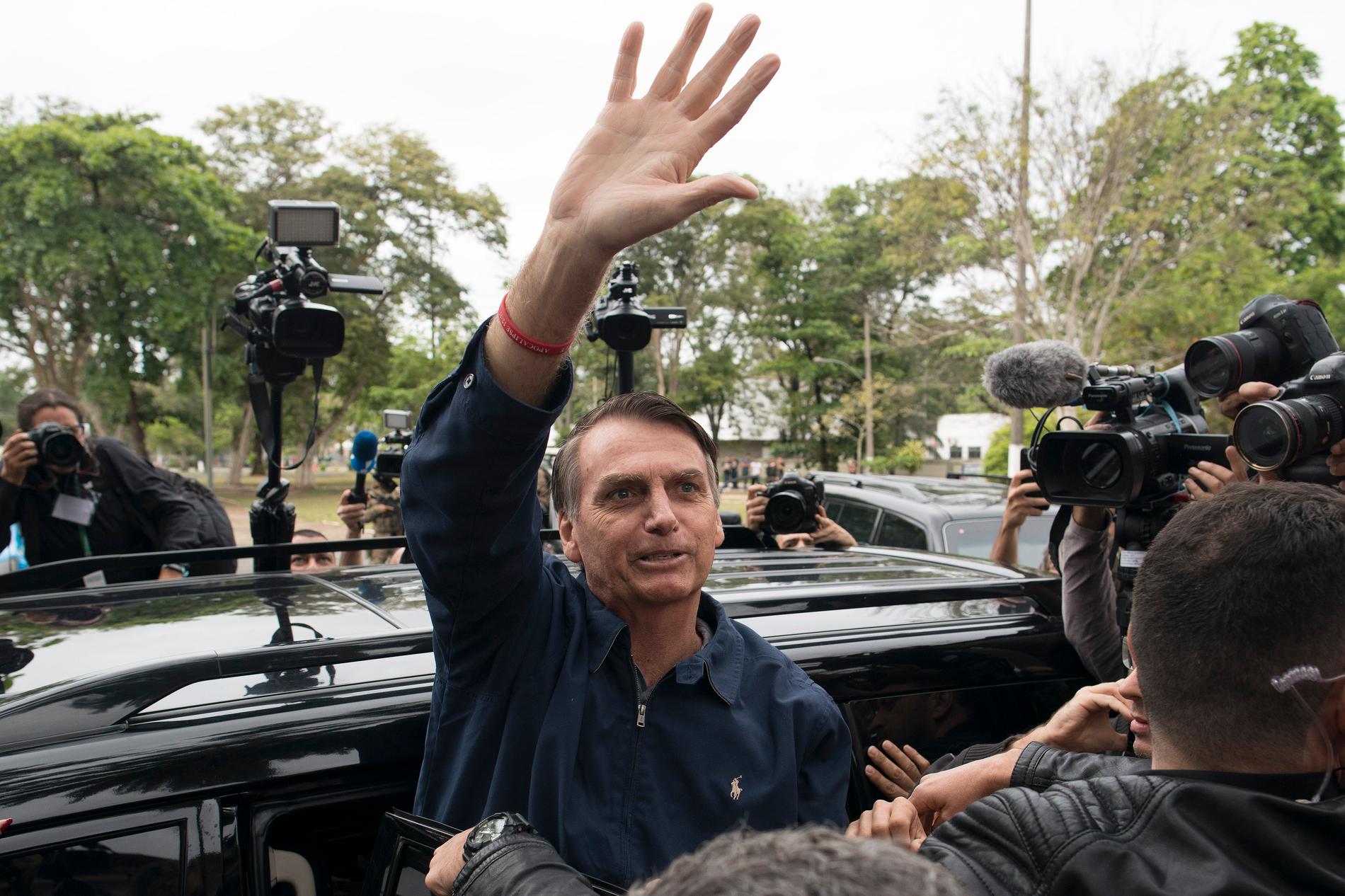 Favoriten i söndagens presidentval i Brasilien, starkt högerinriktade Jair Bolsonaro från Socialliberala partiet (PSL), vinkar till sina anhängare efter att ha röstat i Rio de Janeiro.