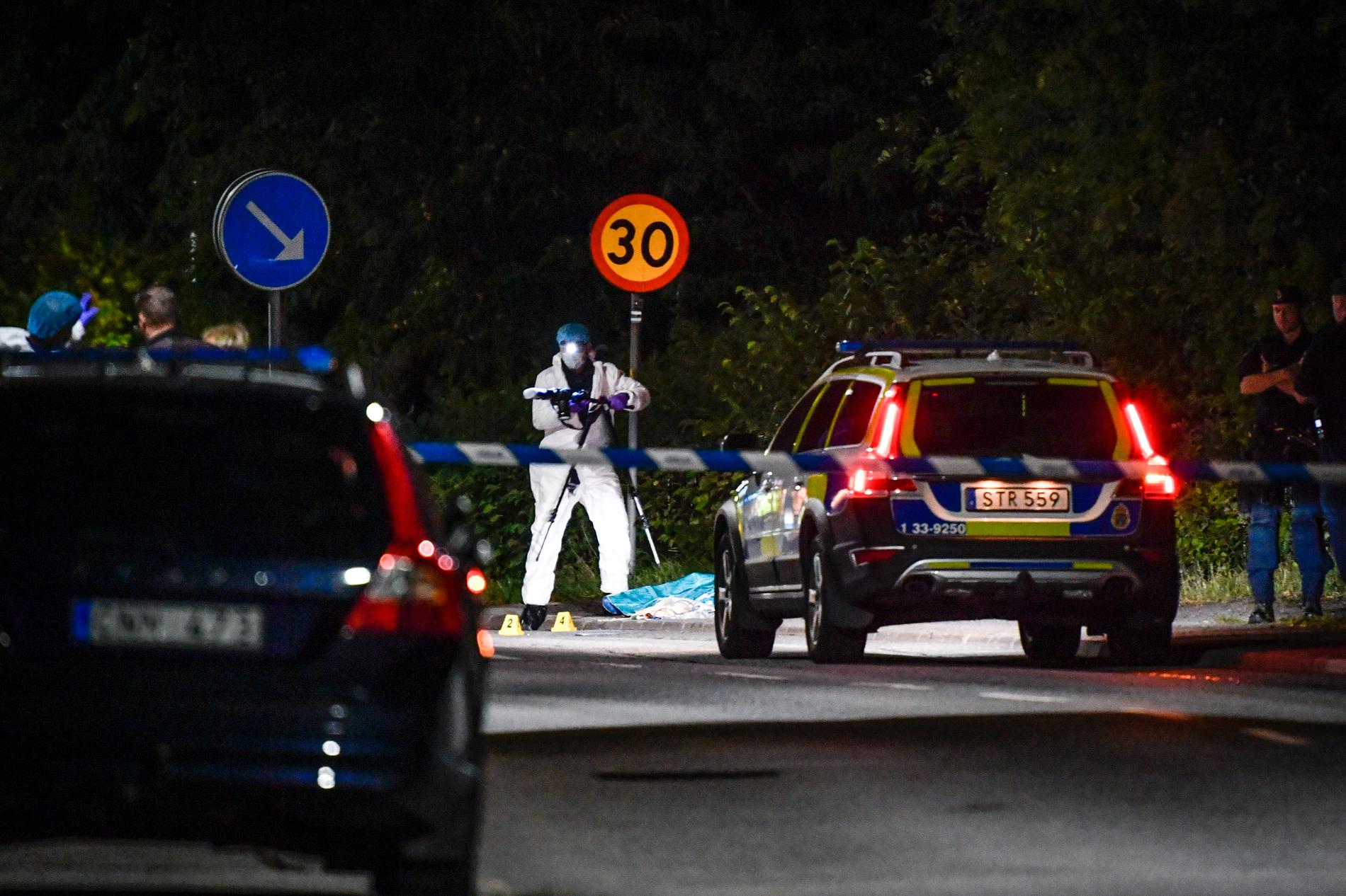 Polis och tekniker vid avspärrning vid den plats i Stocksund strax norr om Stockholm där en man avled efter en skottlossning på måndagskvällen. Tre personer har anhållits misstänkta för mord.