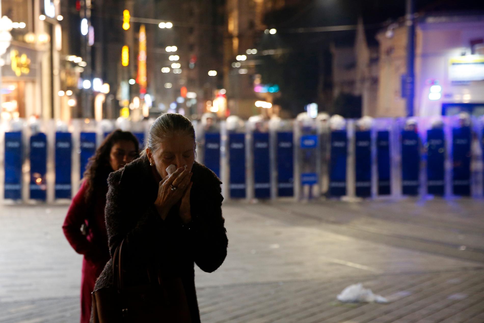 En kvinna reagerar sedan polisen skjutit tårgas på i Istanbul på fredagen.