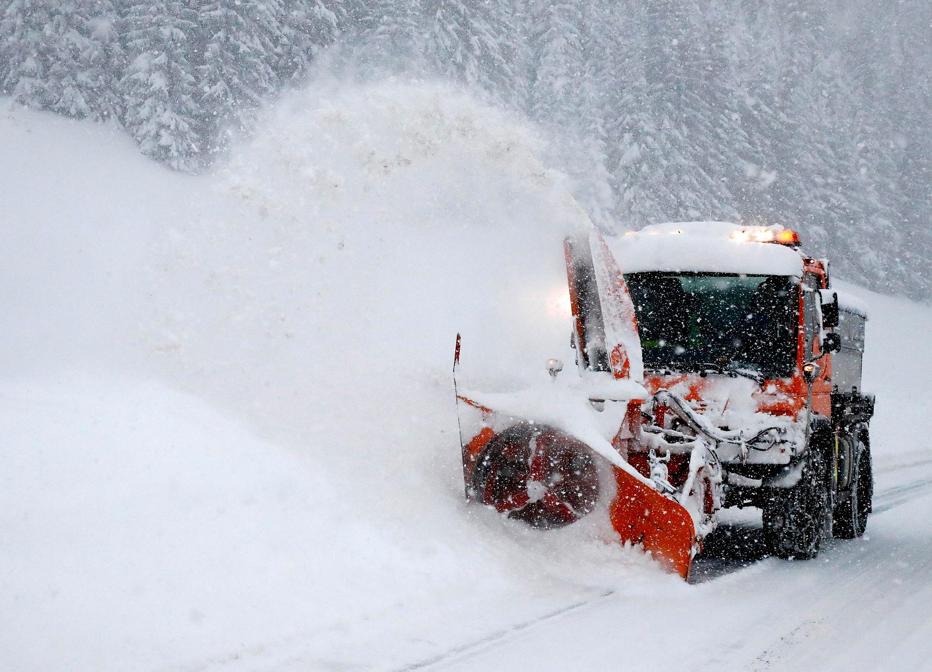 Snö röjs undan från en stängd väg i österrikiska Filzmoos på lördagen.