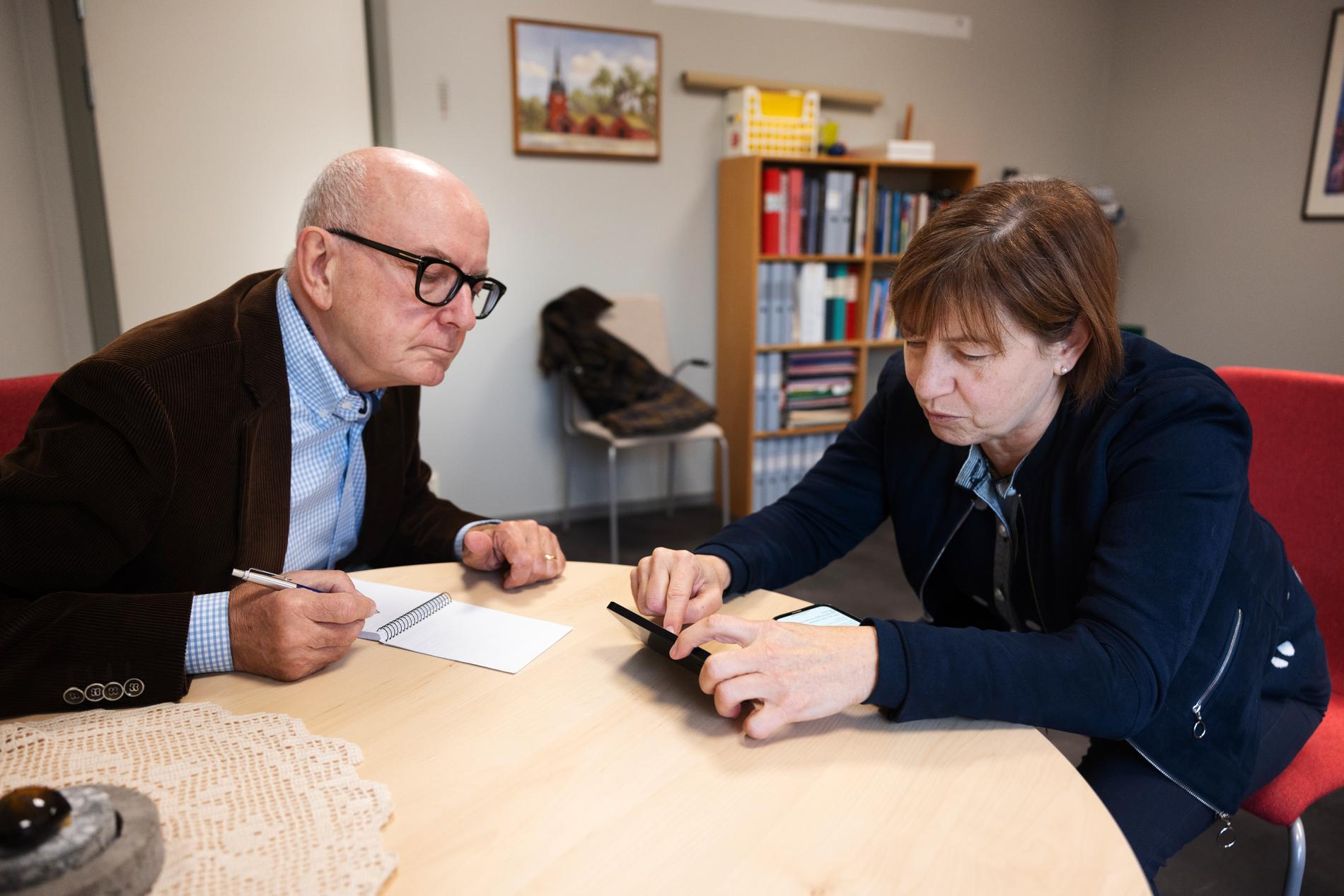 Peter Kadhammar och Ewa-Leena Johansson (S) kollar på listor över skuldsatta i Ljusnarsberg.