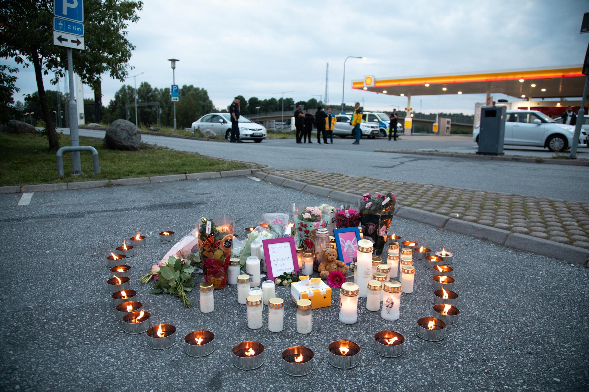 Blommor och ljus på platsen där en tolvårig flicka sköts vid en bensinmack i Norsborg söder om Stockholm. Arkivbild.