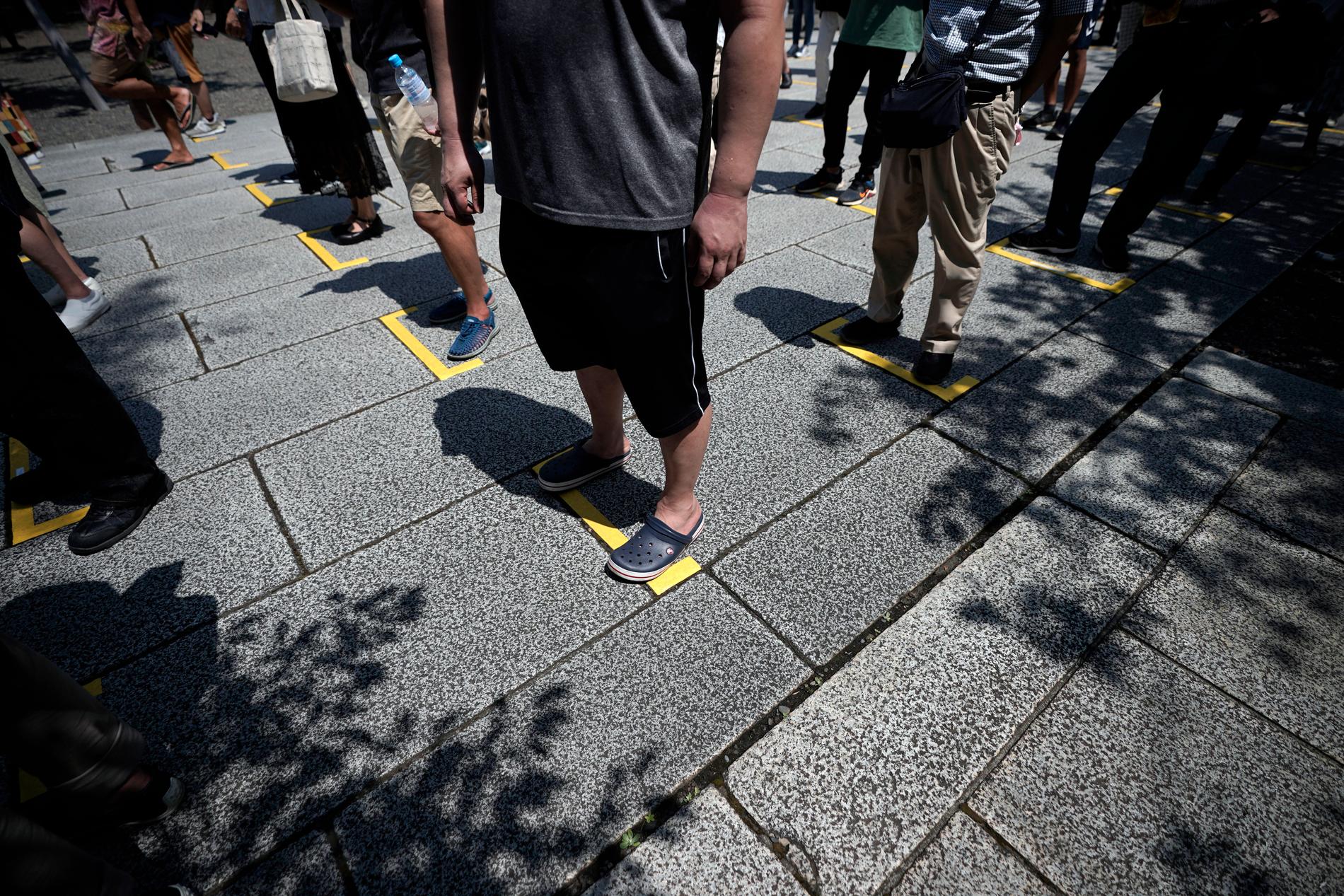 Besökare vid helgedomen Yasukuni Jinja köar med social distansering i ett försök att hindra smittspridning under årsdagen.