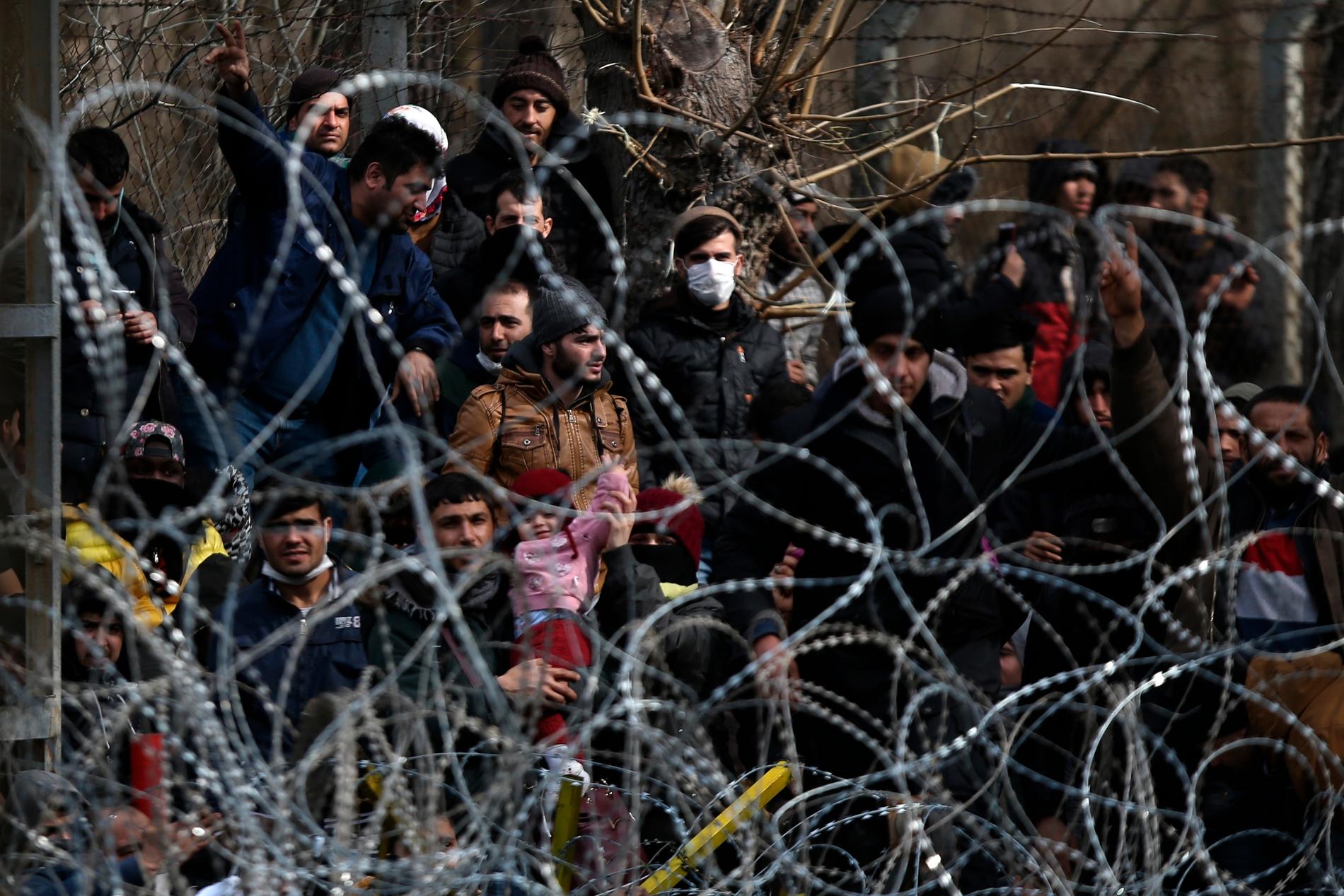 Migranter bakom en avspärrning nära den grekisk-turkiska gränsen i Kastanies.