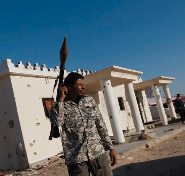 Beväpnad En libysk rebell bär på ett granatgevär sent på lördagseftermiddagen i stadenAjdabiyah.