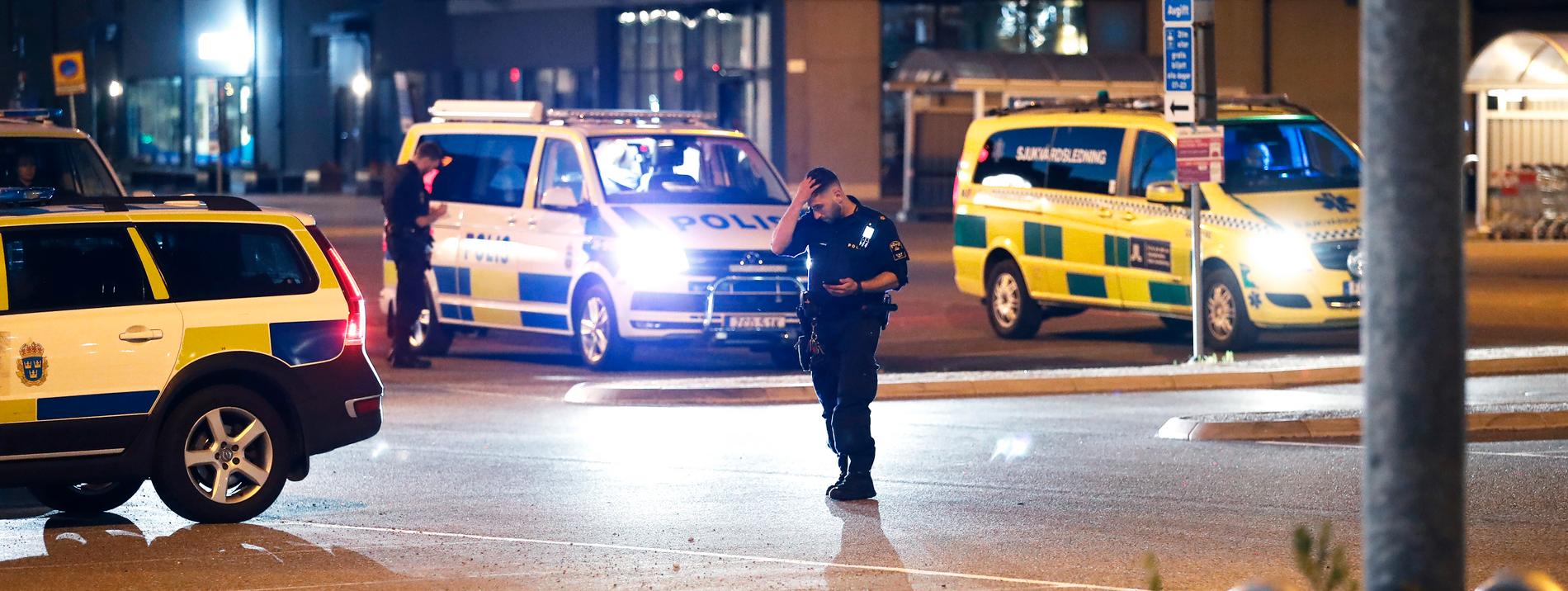  Poliser och ambulans utanför ICA Maxi i Flemingsbergs centrum efter att en person hittats med misstänkta skottskador utomhus.