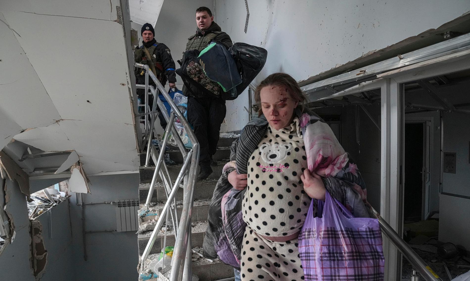 En skadad gravid kvinna tar sig nedför trapporna efter att en barn- och förlossningsklinik utsatts för en rysk robotattack under onsdagen.