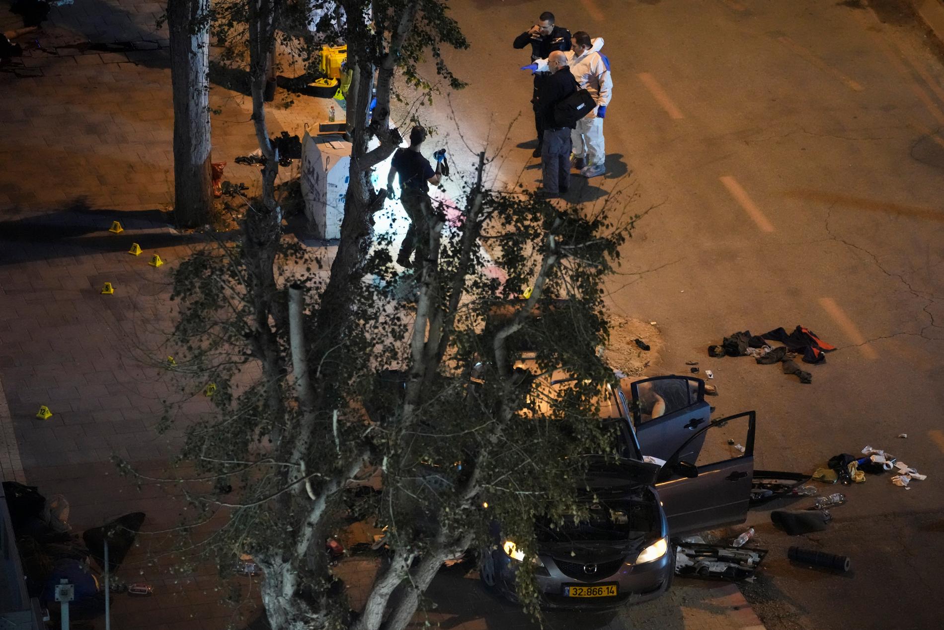 Israelisk polis undersöker platsen där två poliser sköts till döds i ett terrordåd i staden Hadera i norra Israel.