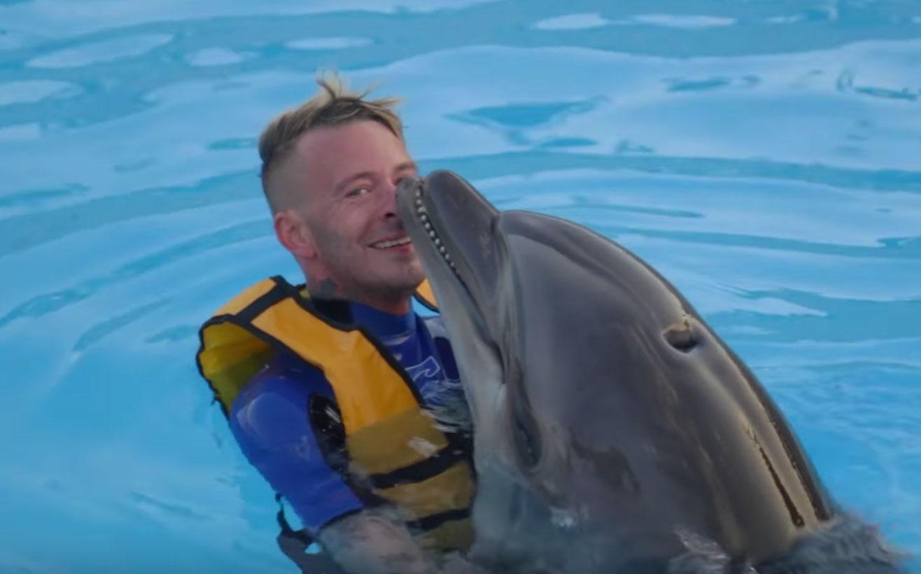 Joakim "Jockiboi" Lundell simmar med delfiner, något som nu kritiseras av Djurens rätt.
