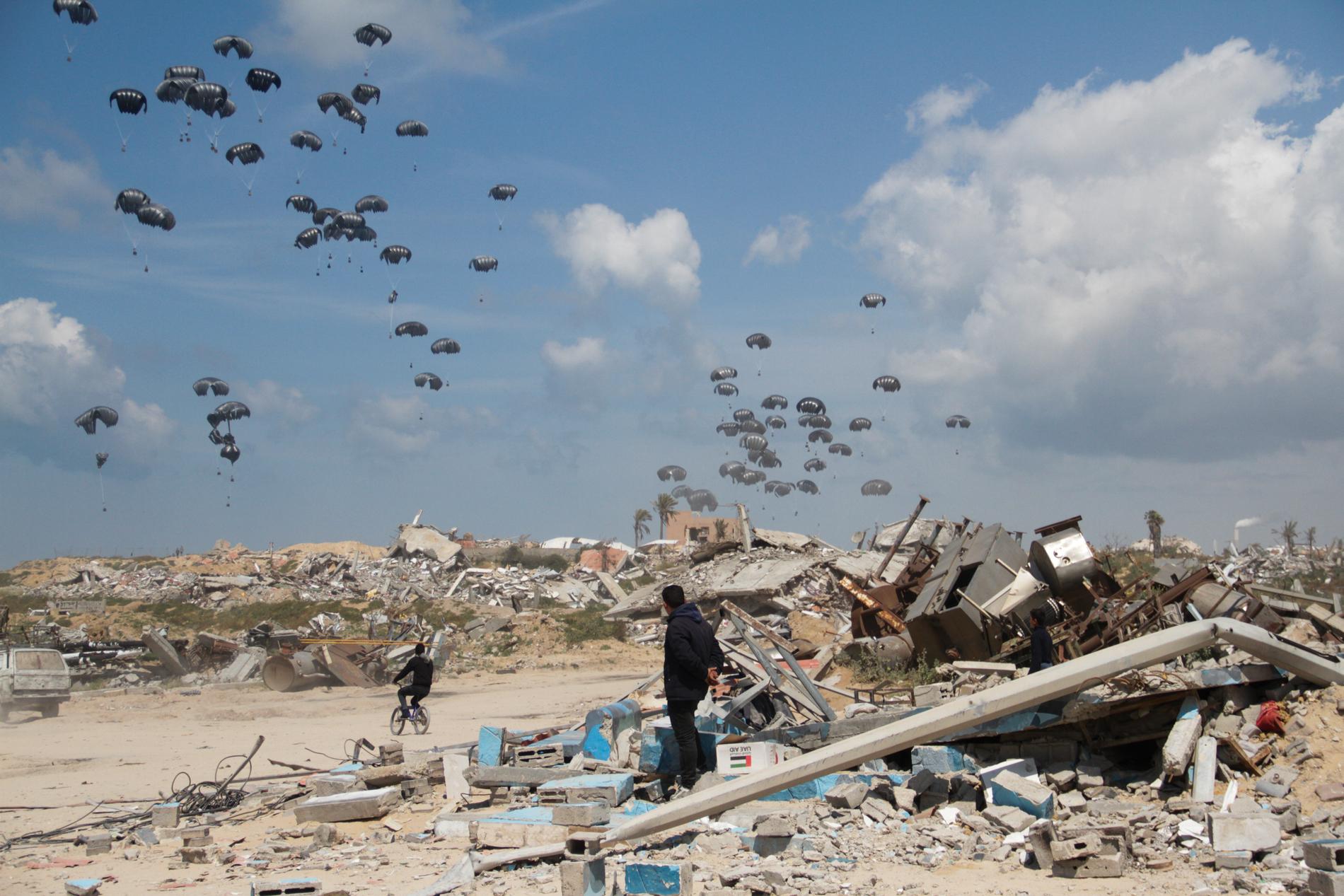 Humanitärt stöd som släppts ur flygplan seglar ner över Gaza City i mars. 